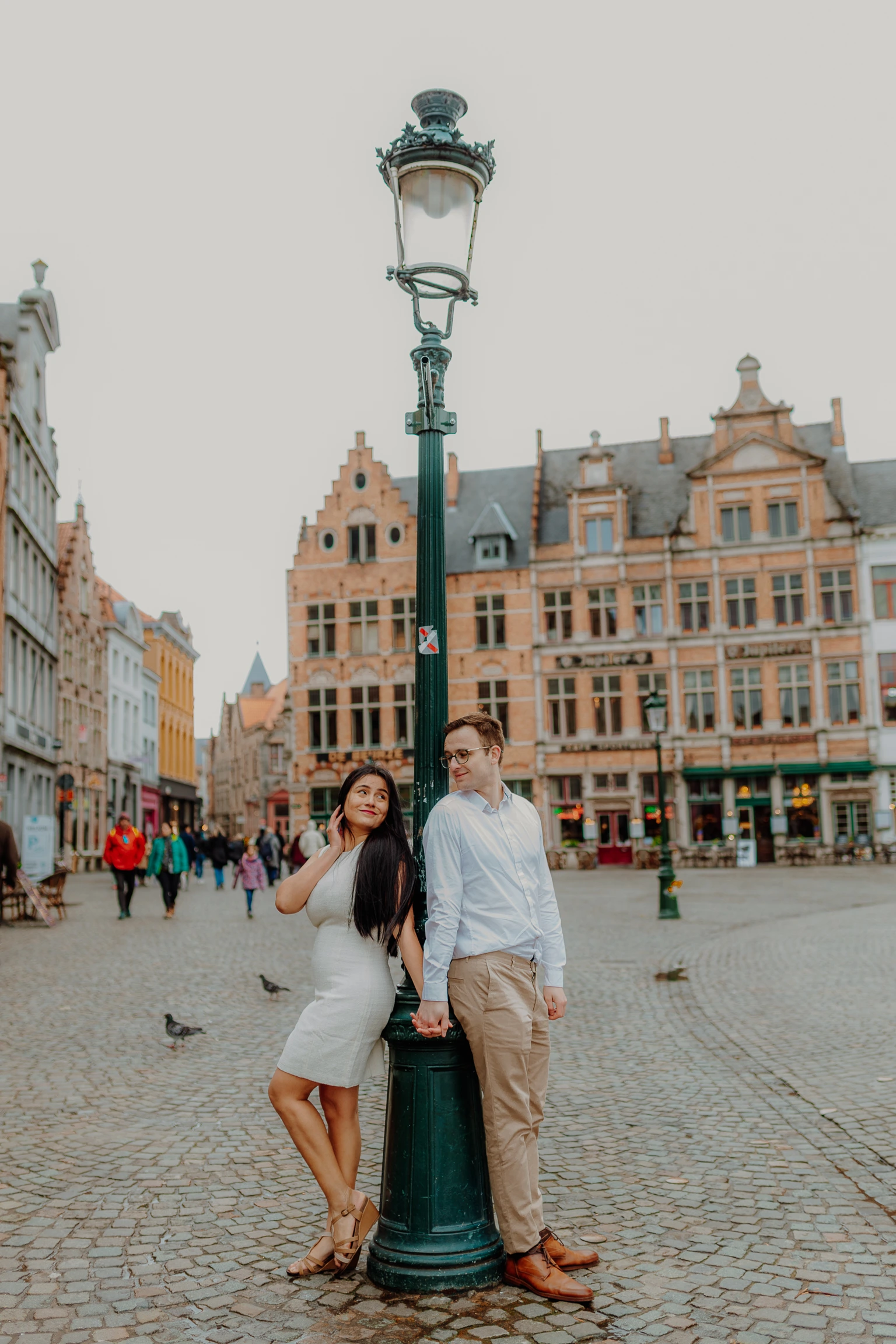 Paar vor roten Hausern und altem Pflastersteinweg