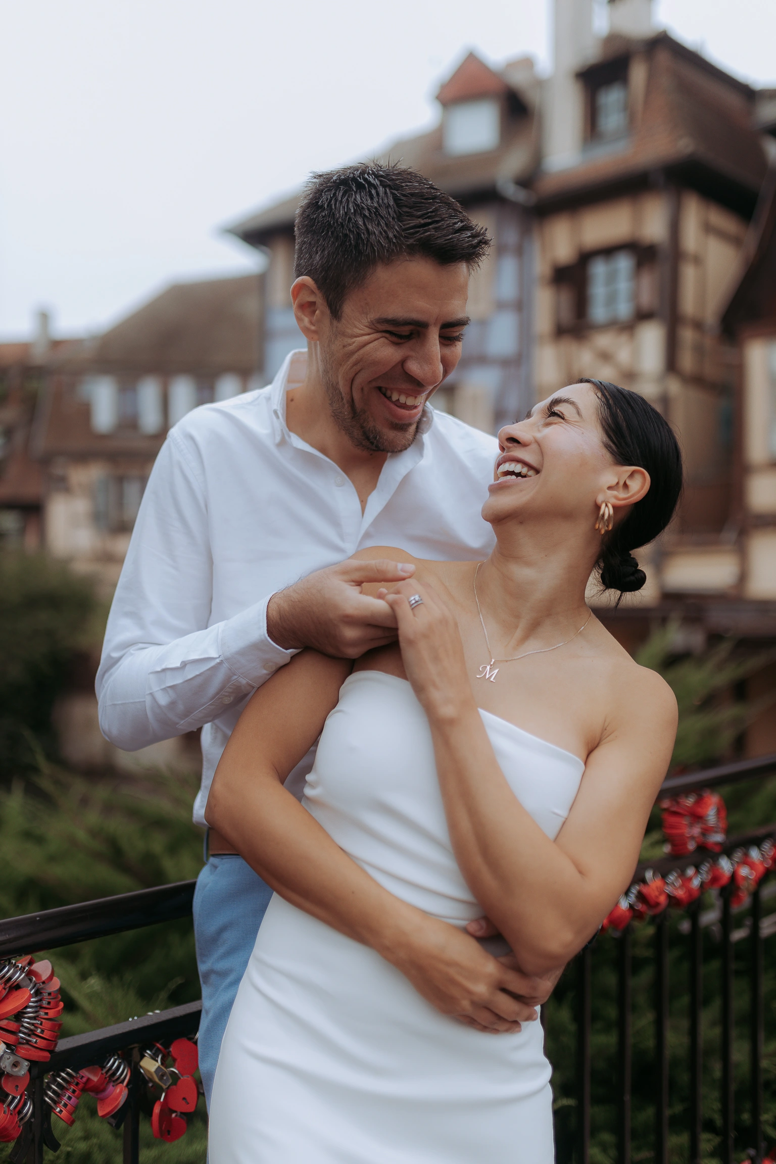 Laughing couple in front of historic half-timbered houses in Colmar, Alsace, France – couple photoshoot
