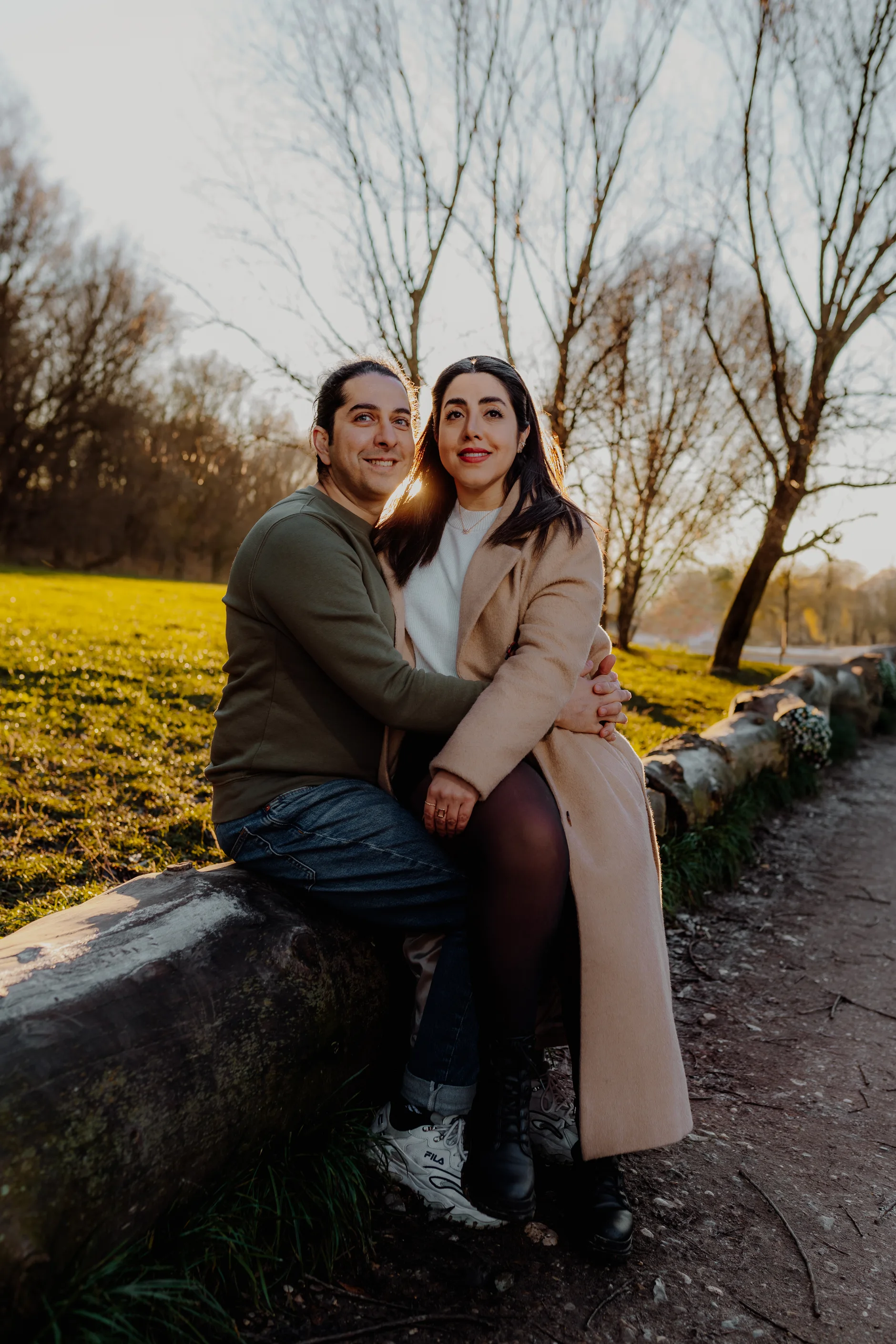 Couple sitting on a stone wall in the evening sun