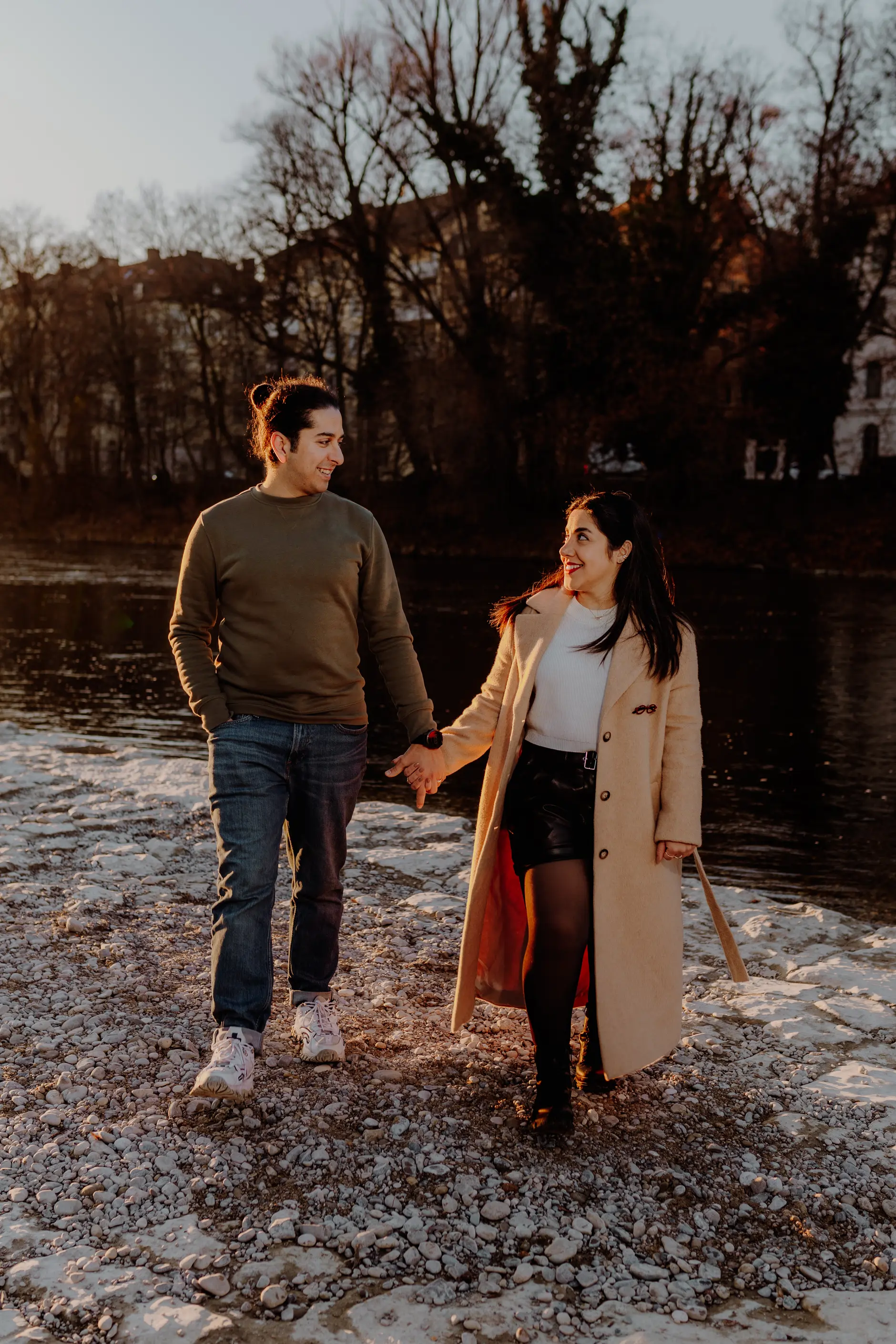 Relaxed portrait — couple seated on a mossy rock in dappled light