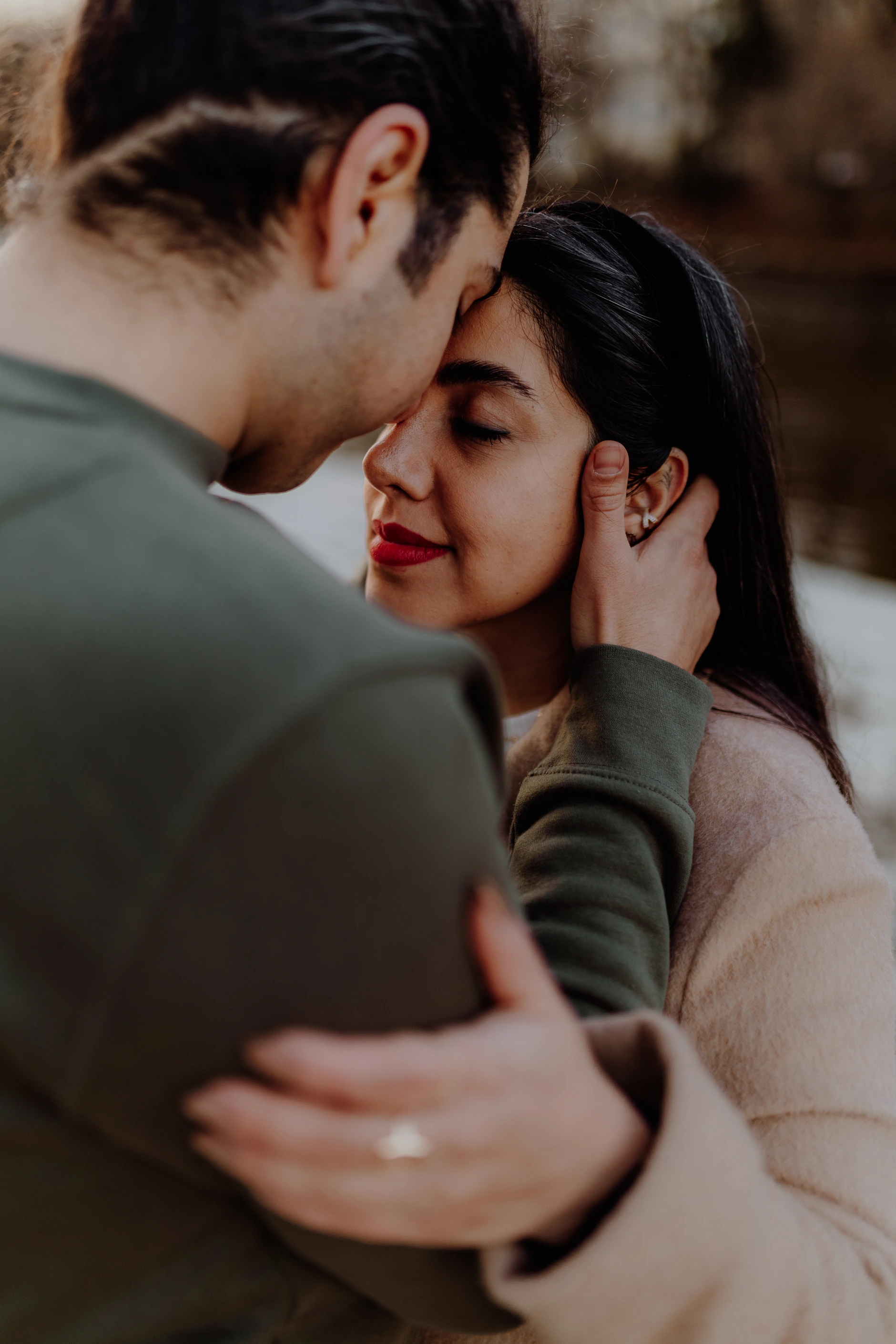 Couple sitting back-to-back on a large flat stone