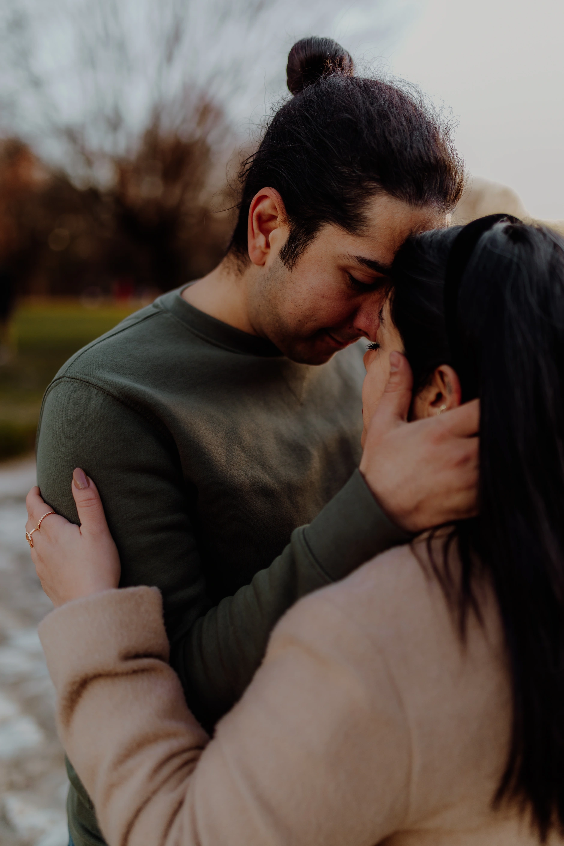 Tender look between the couple — long grass in the foreground