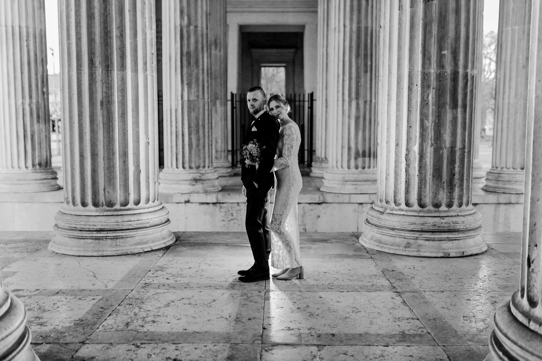 Black-and-white groom between monumental columns