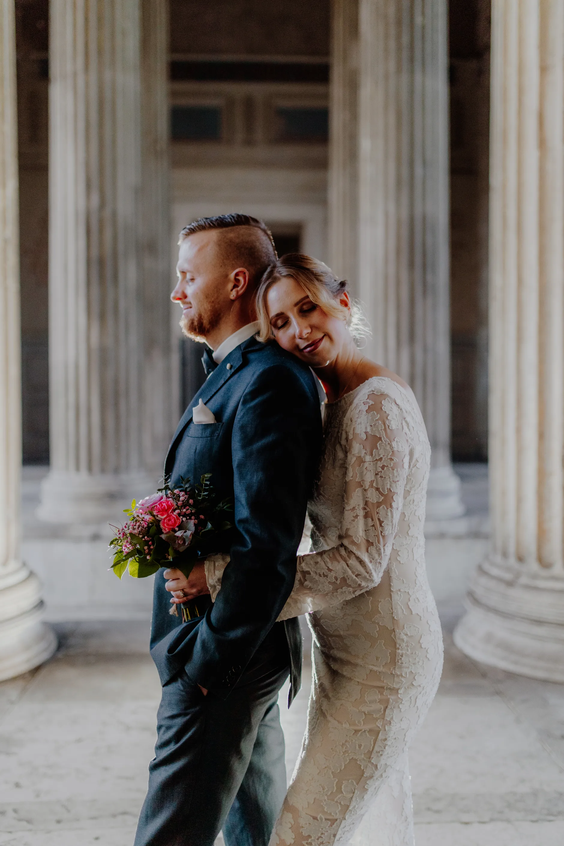 Couple embracing in front of classical architecture