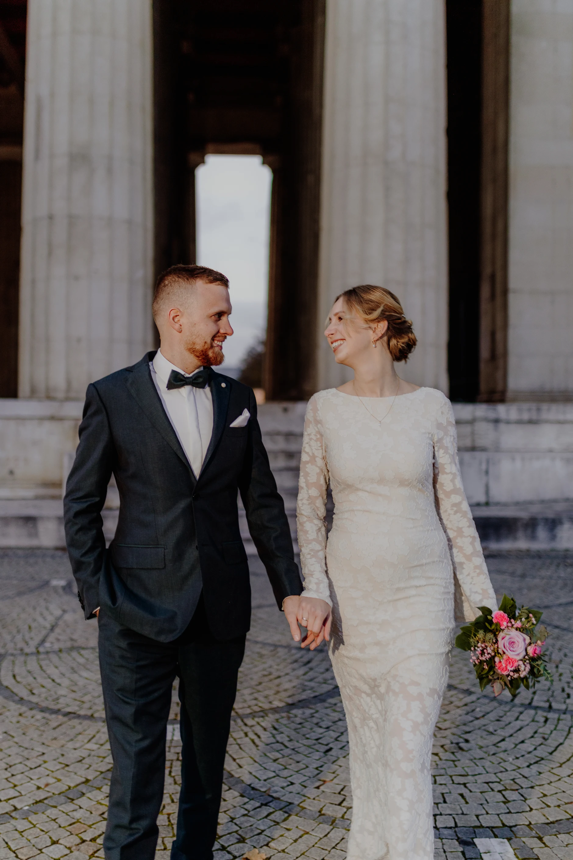 Couple portrait in warm side light between the pillars