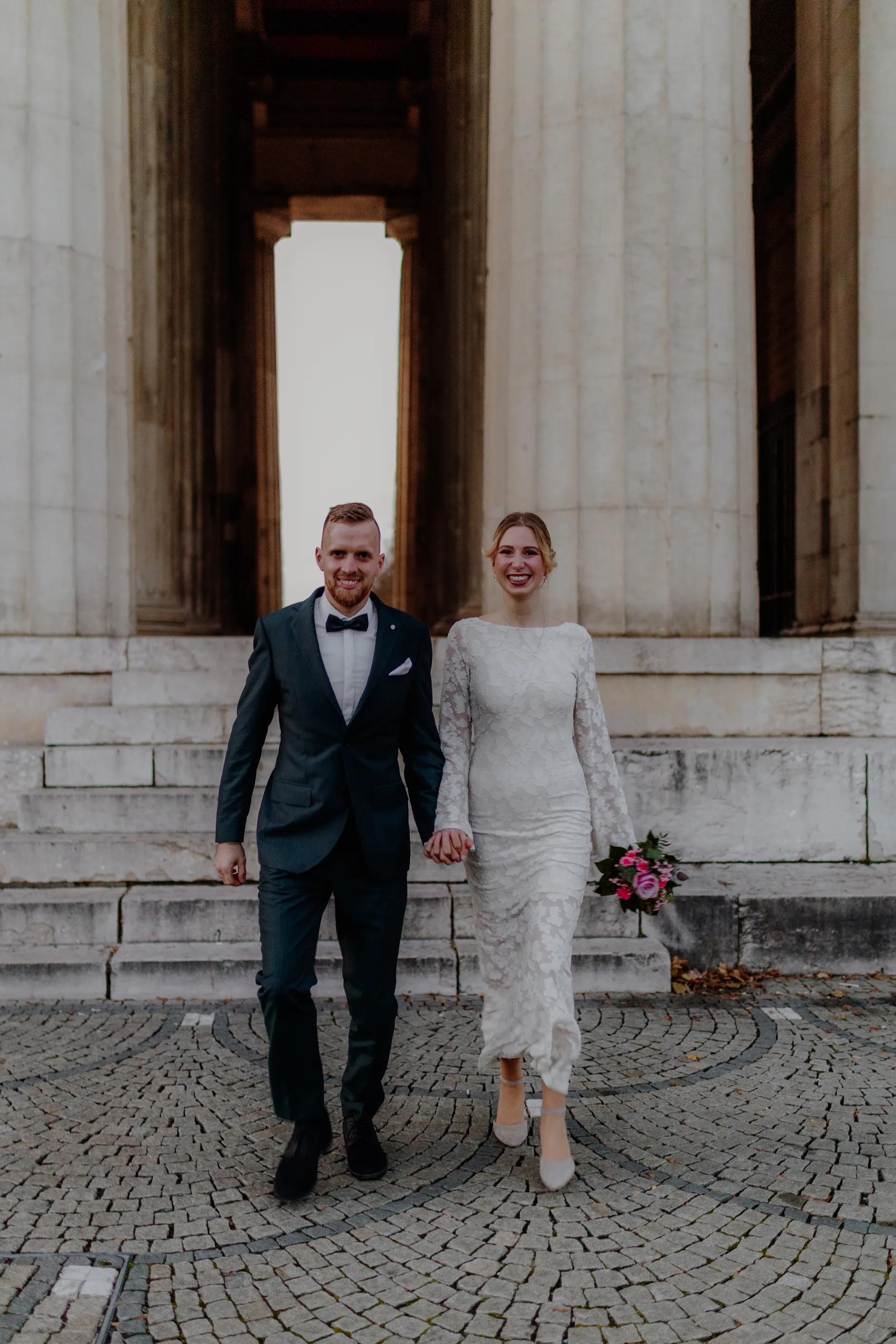 Couple side by side in the colonnade's deep shade
