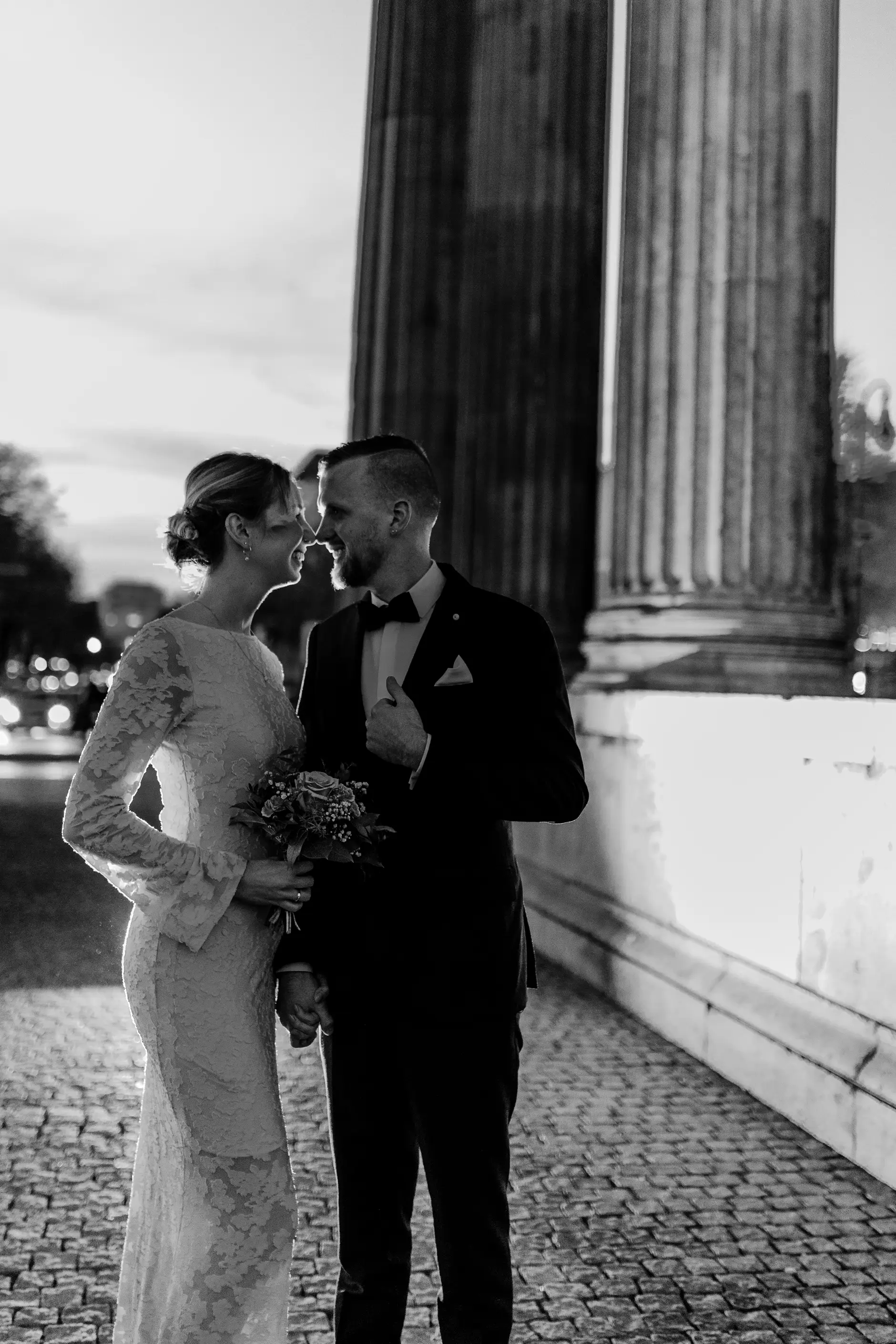 Intimate embrace in shallow focus, columns blurred behind