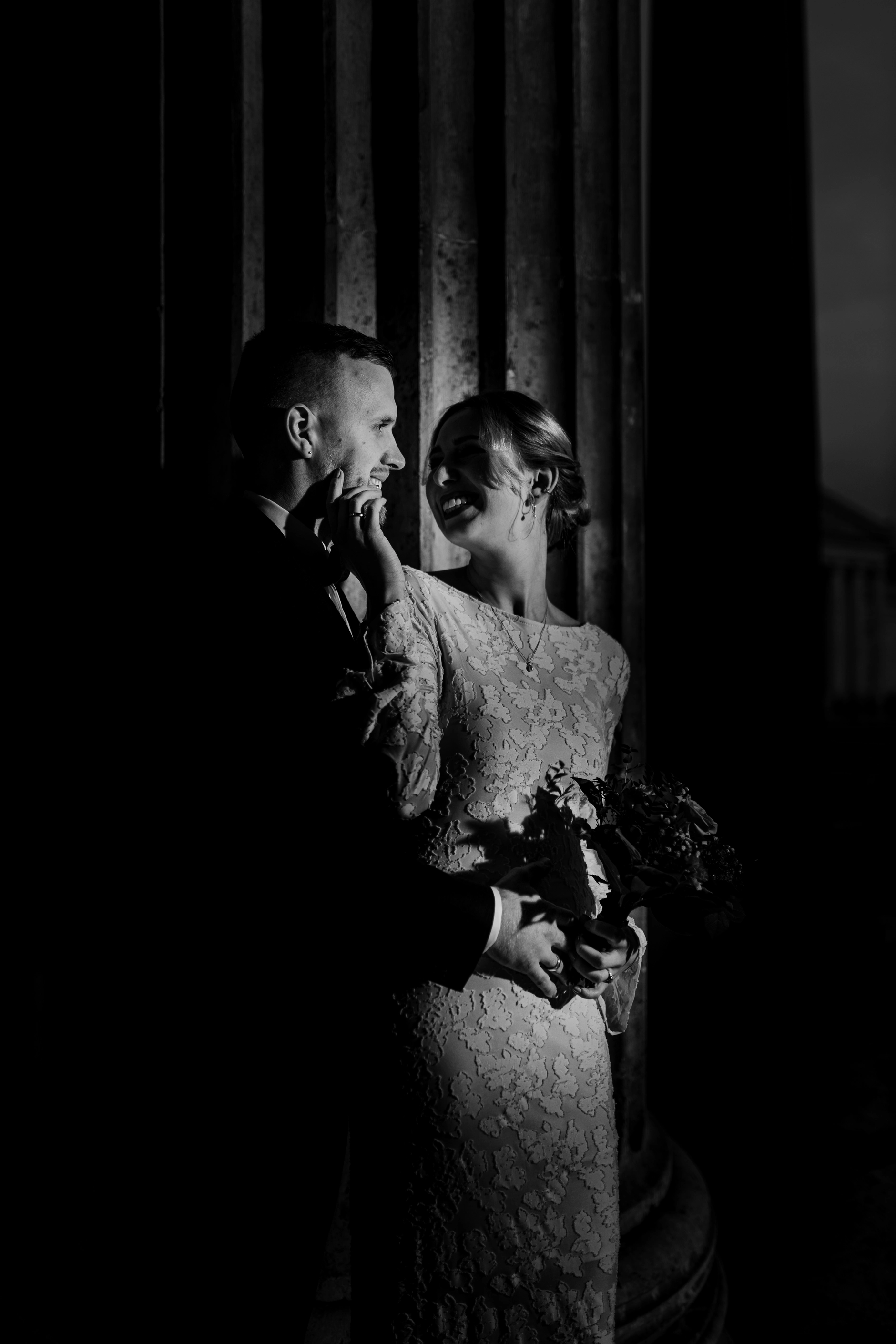 Bride with bouquet in the shadow of the columns