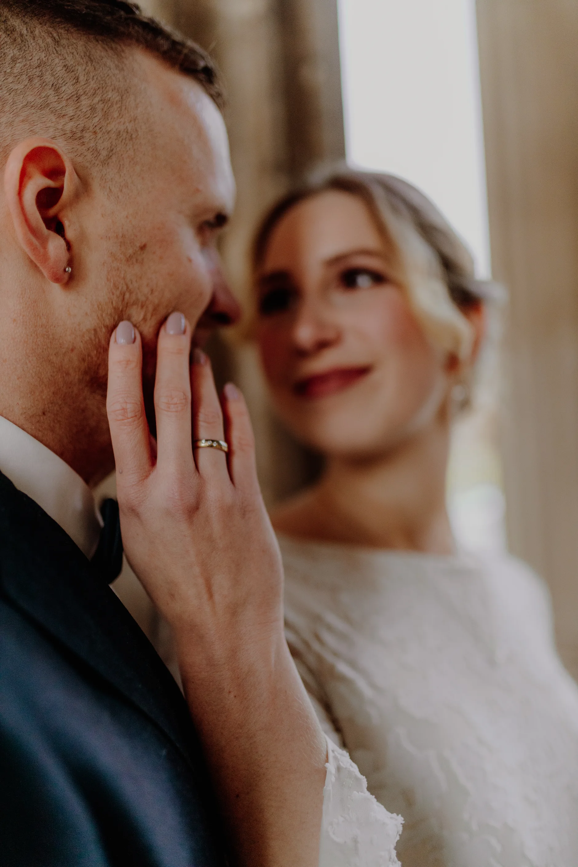 Detail of the bride's hand against the groom's face