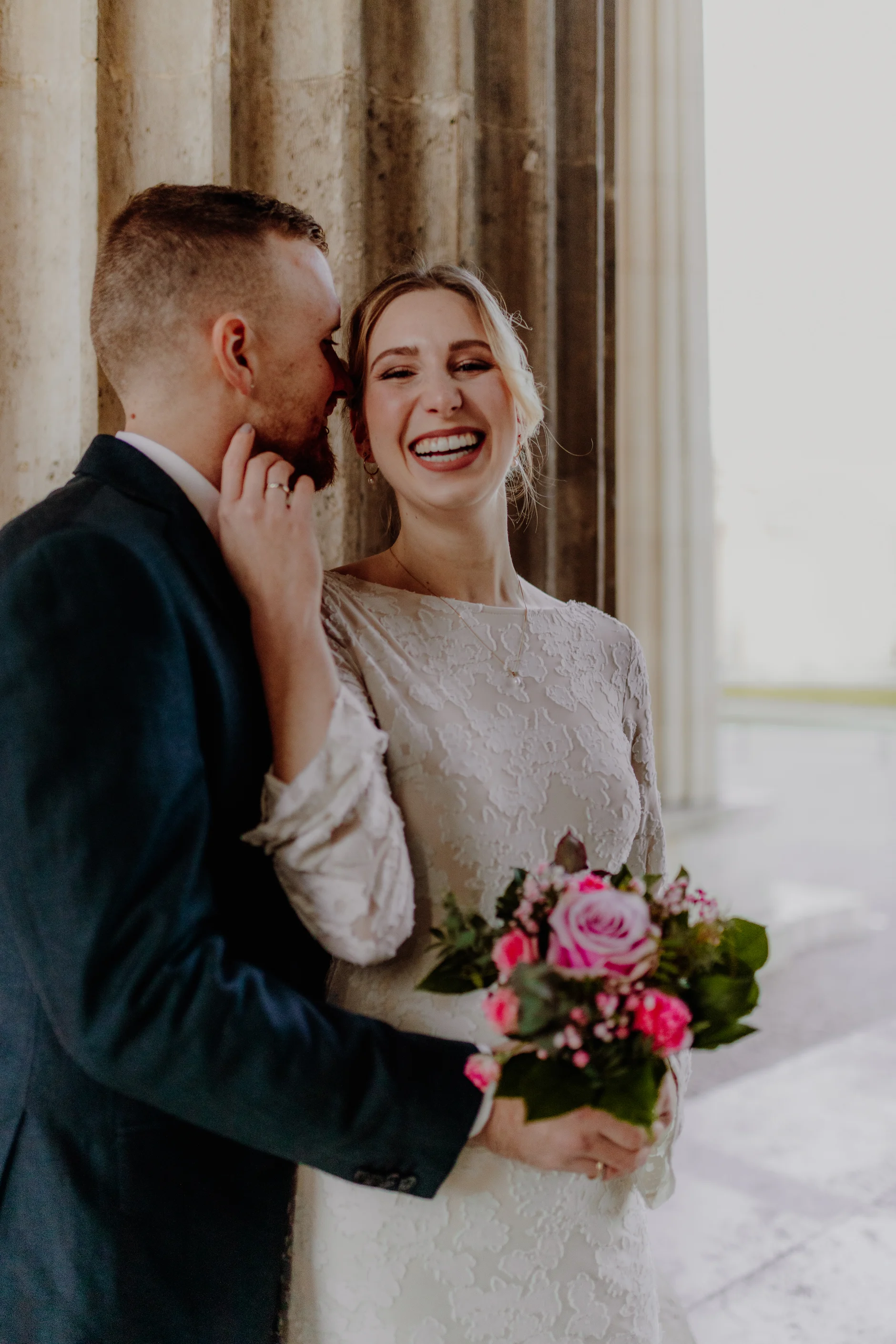 Laughing couple in warm light between the columns