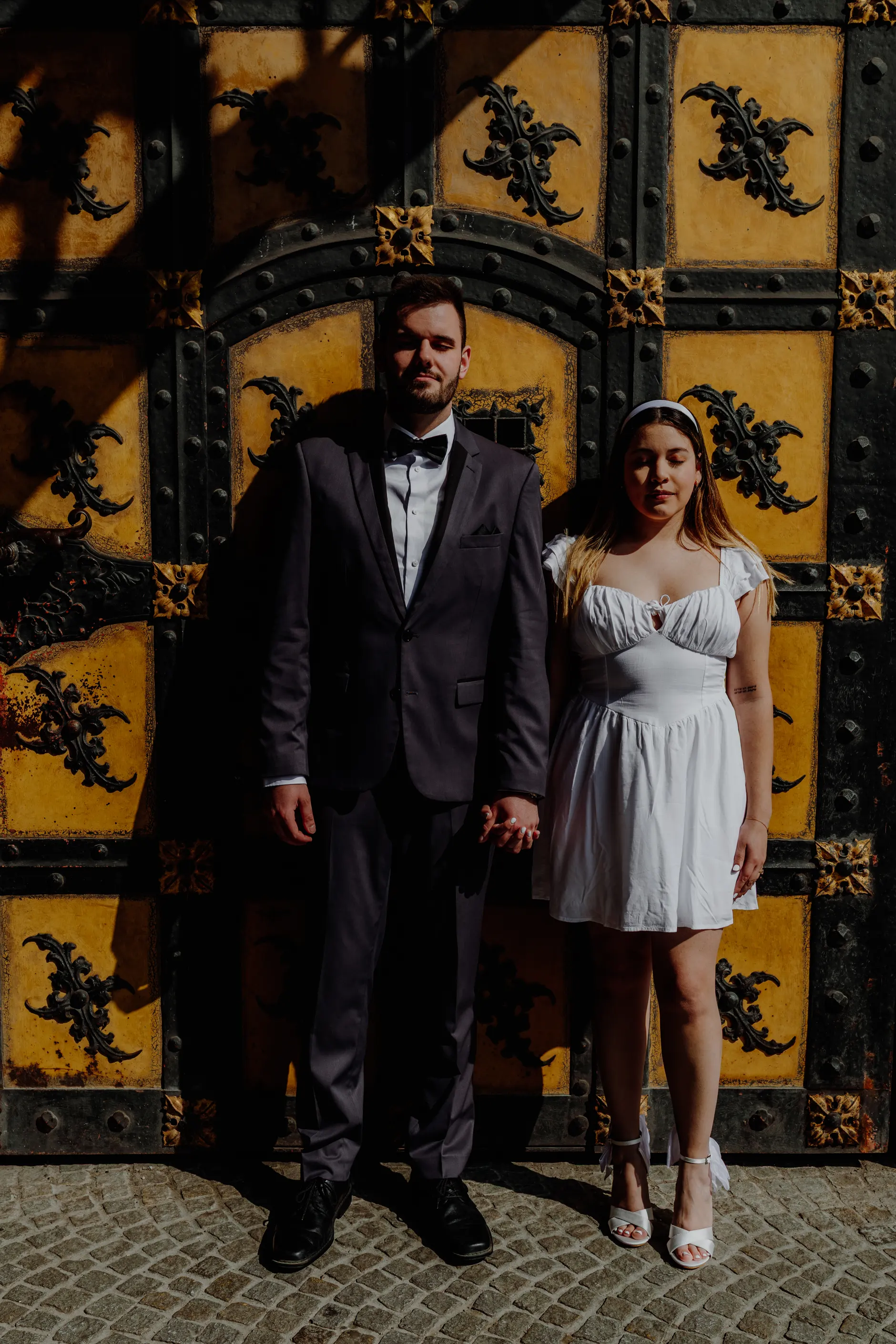 Couple posing at the ornate yellow and black Rathaus door