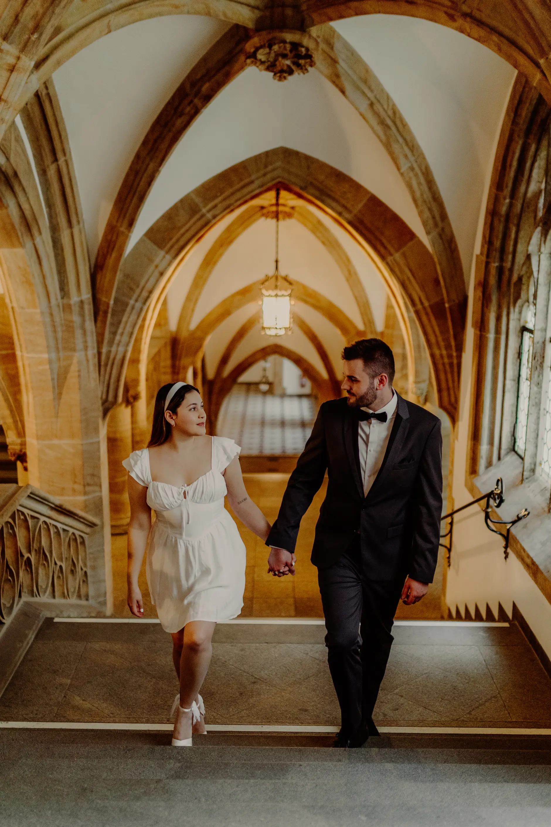 Couple walking through a vaulted Marienplatz hallway