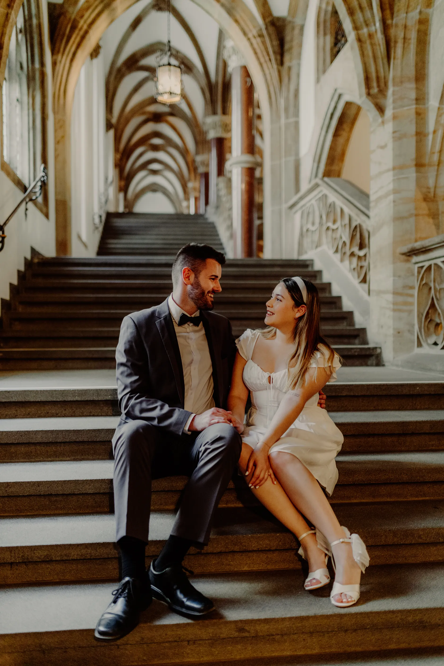 Couple seated on stairs inside Munich City Hall