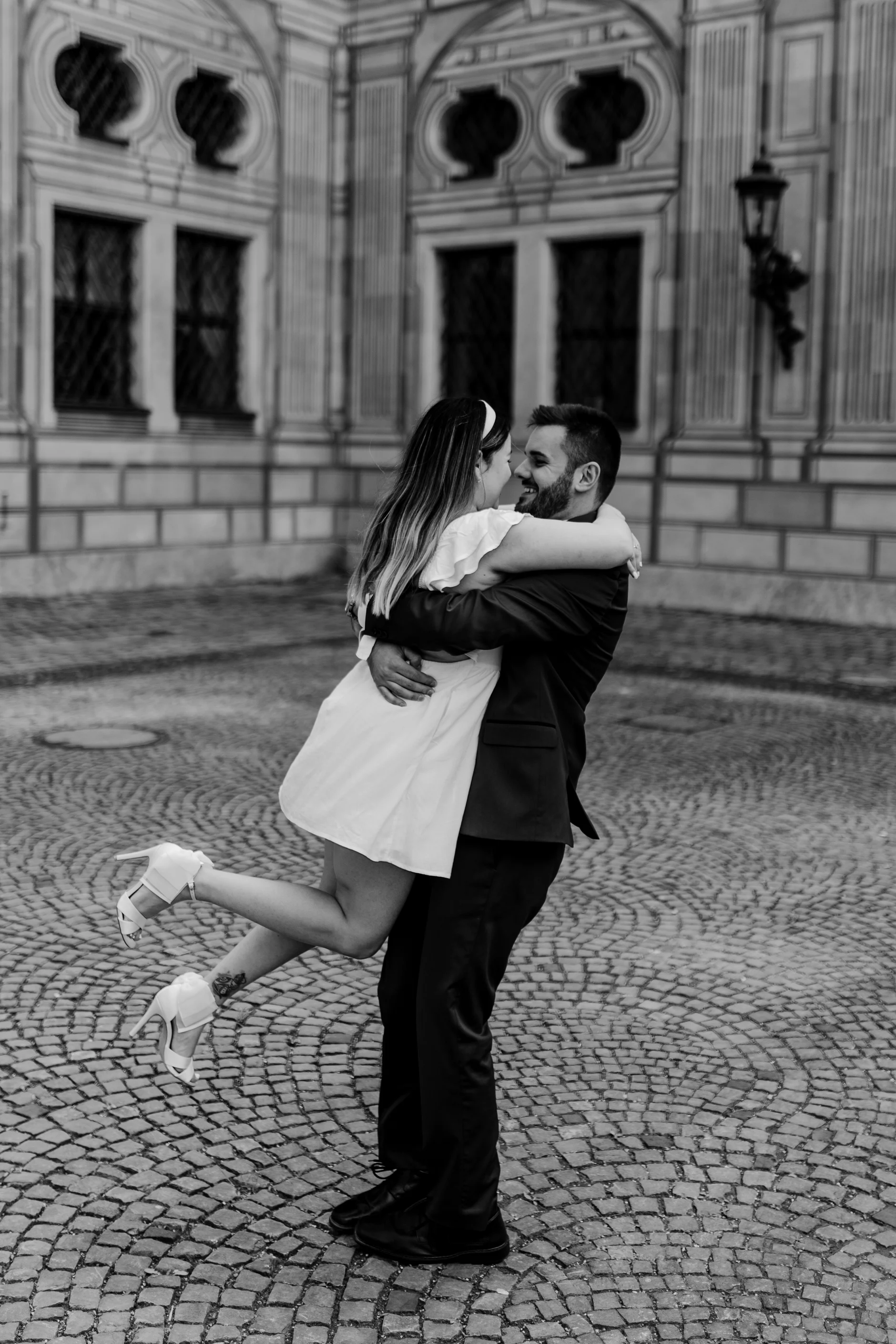 Groom dancing with the bride in front of the Rathaus facade