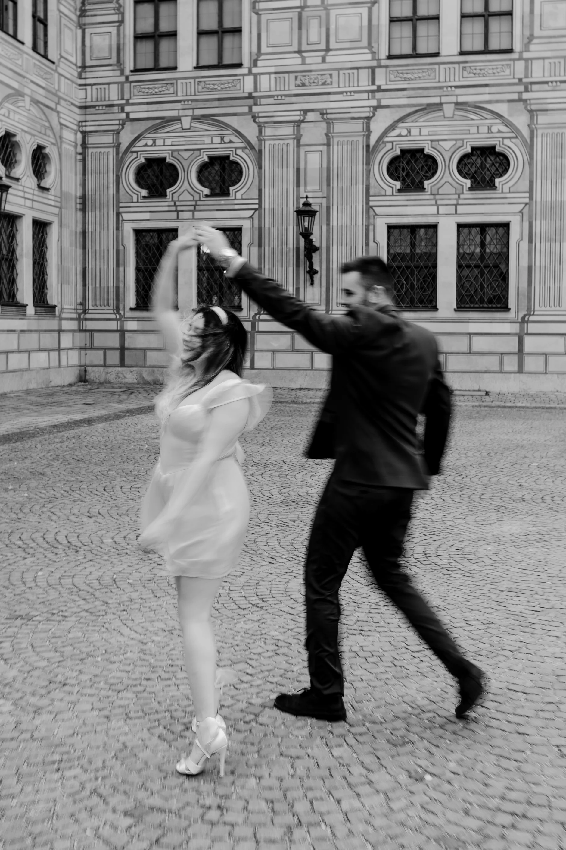 Wide action shot of the dance on wet cobblestones