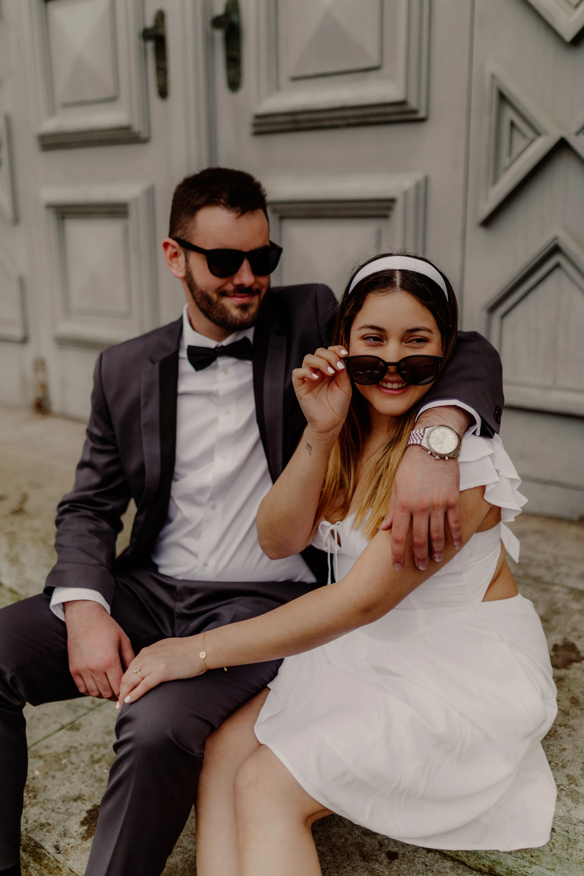 Couple portrait sitting close together by the arches