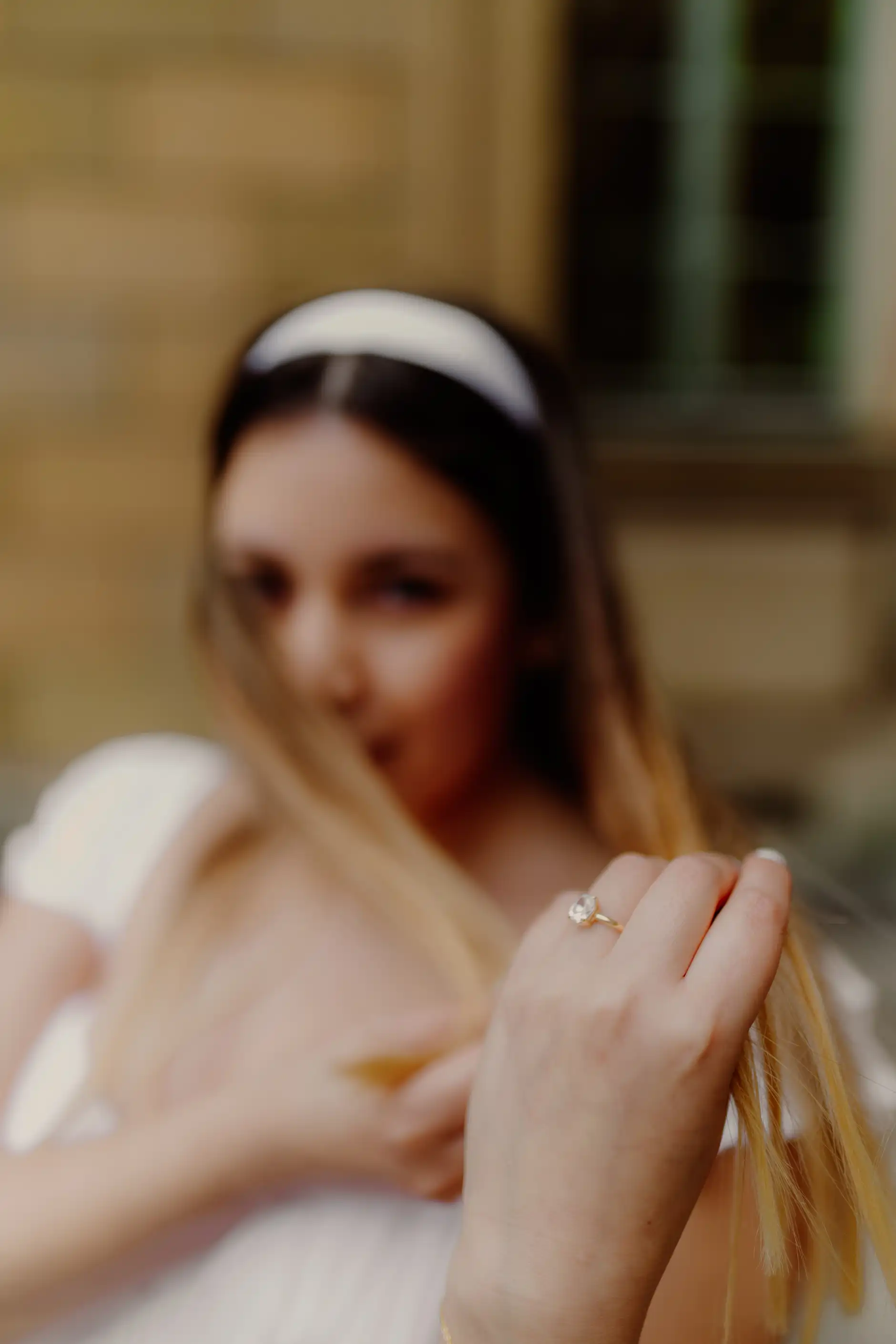 Soft focus portrait highlighting the engagement ring