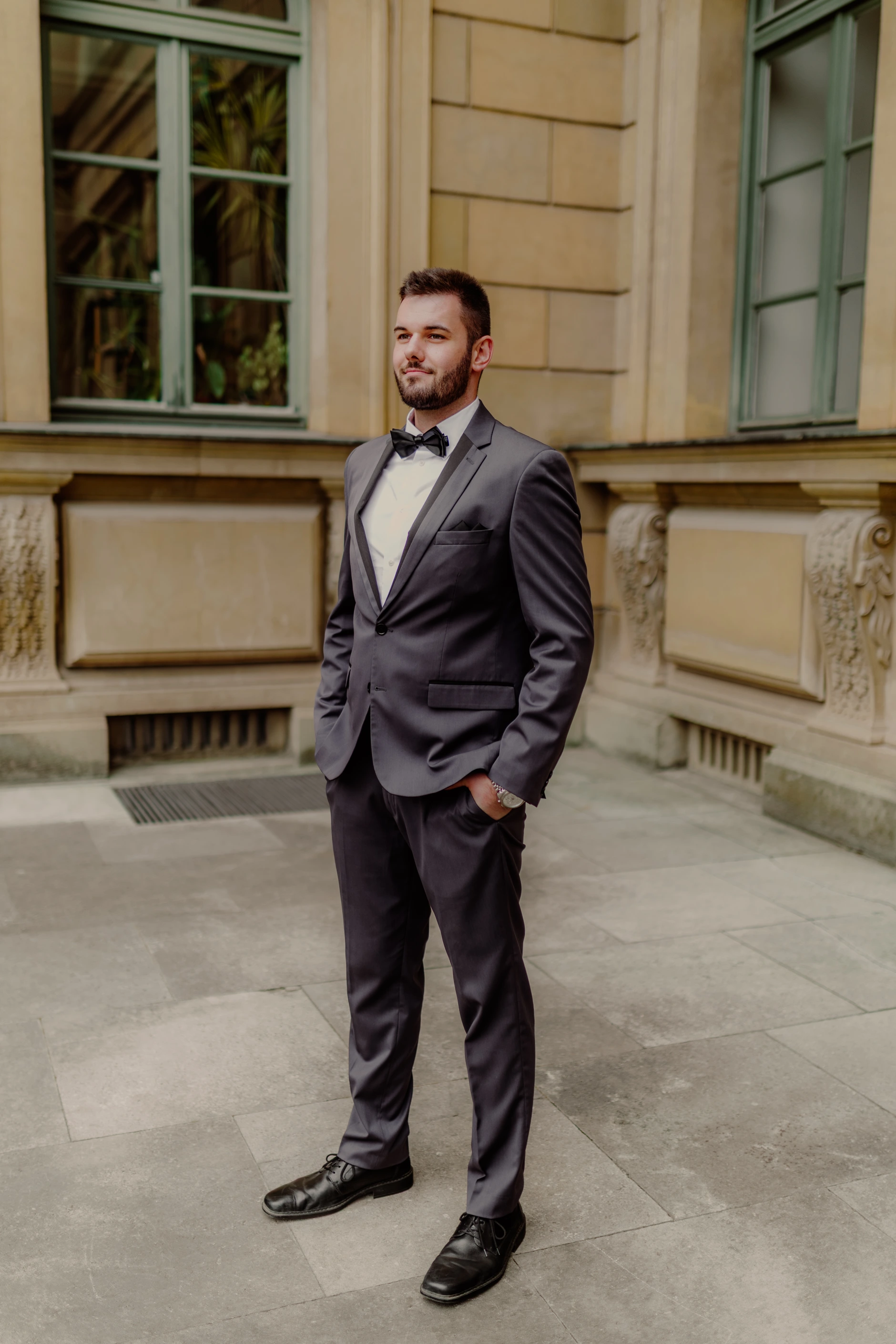 Full-length portrait of the groom in a gray suit
