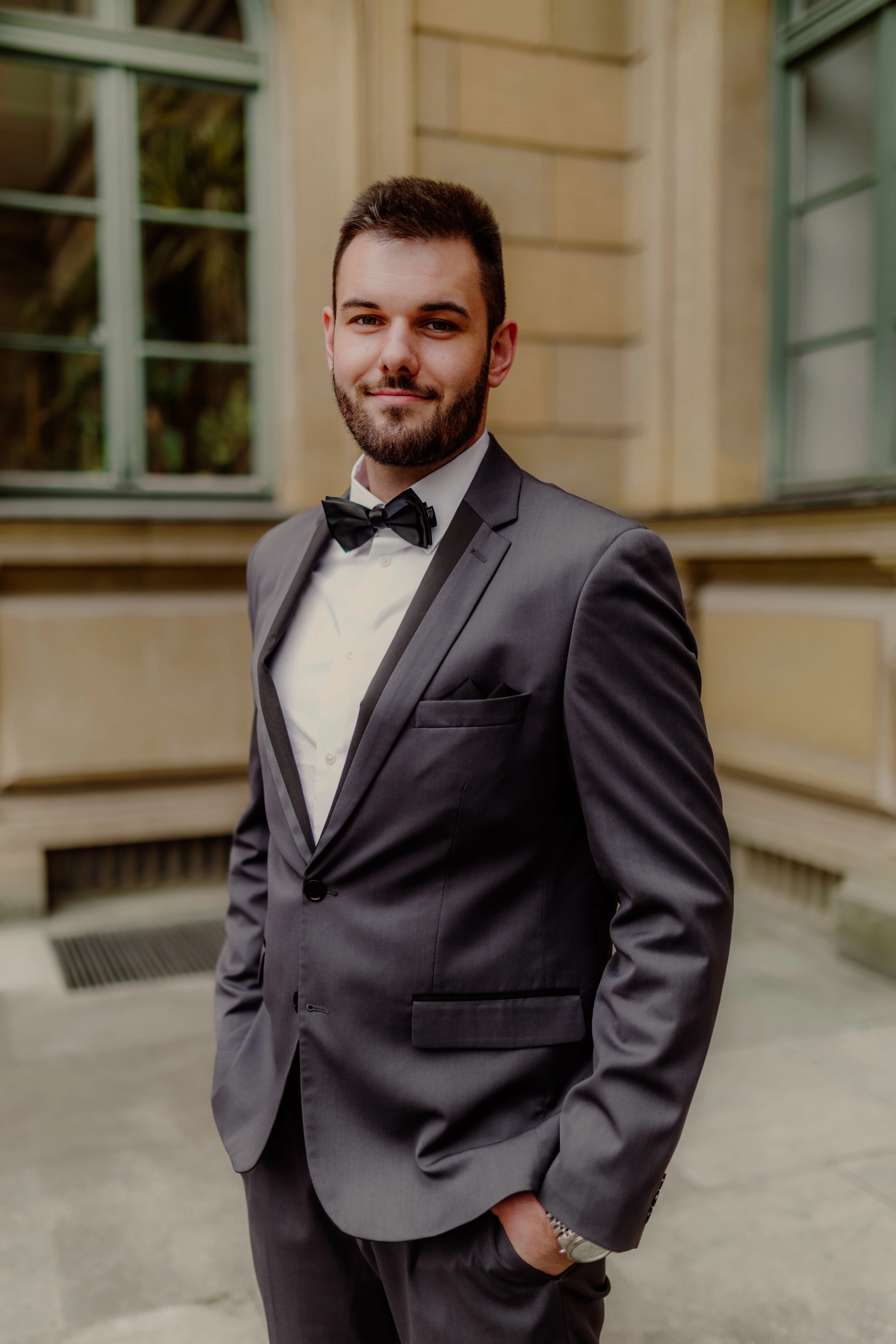 Half-length groom portrait in front of Munich architecture