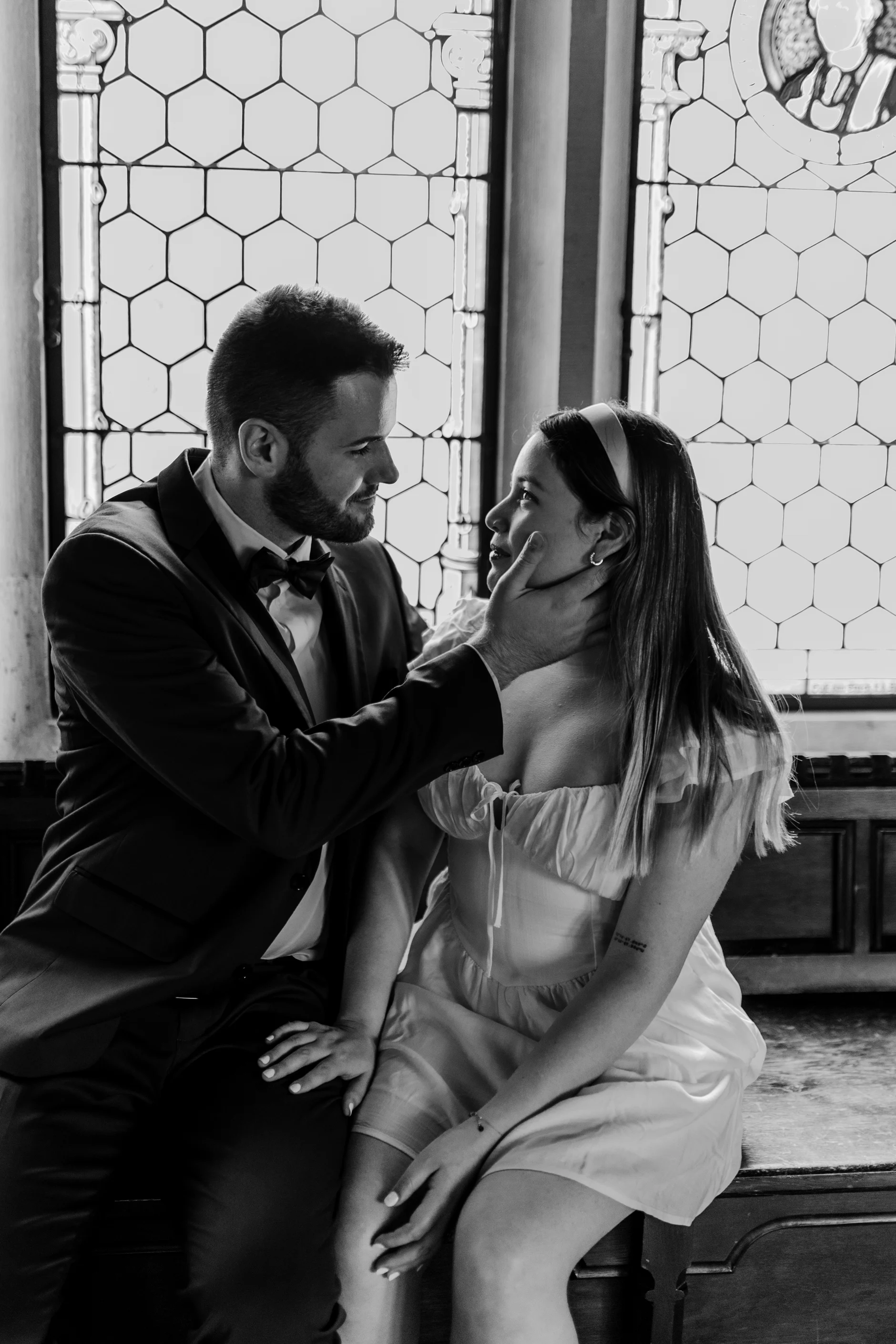 Black and white embrace in front of old glass doors