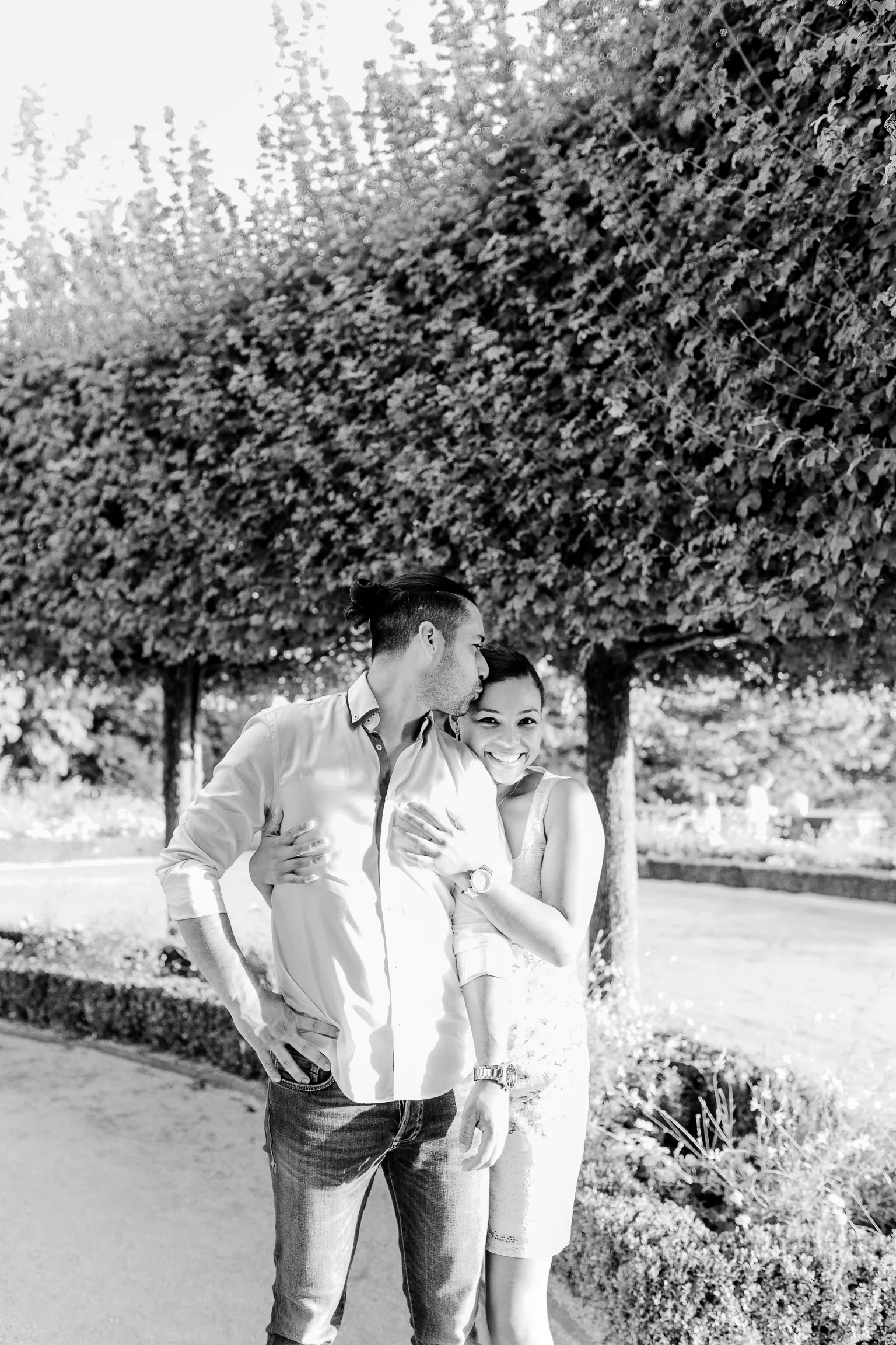 Black and white shot of the couple walking beside the wall