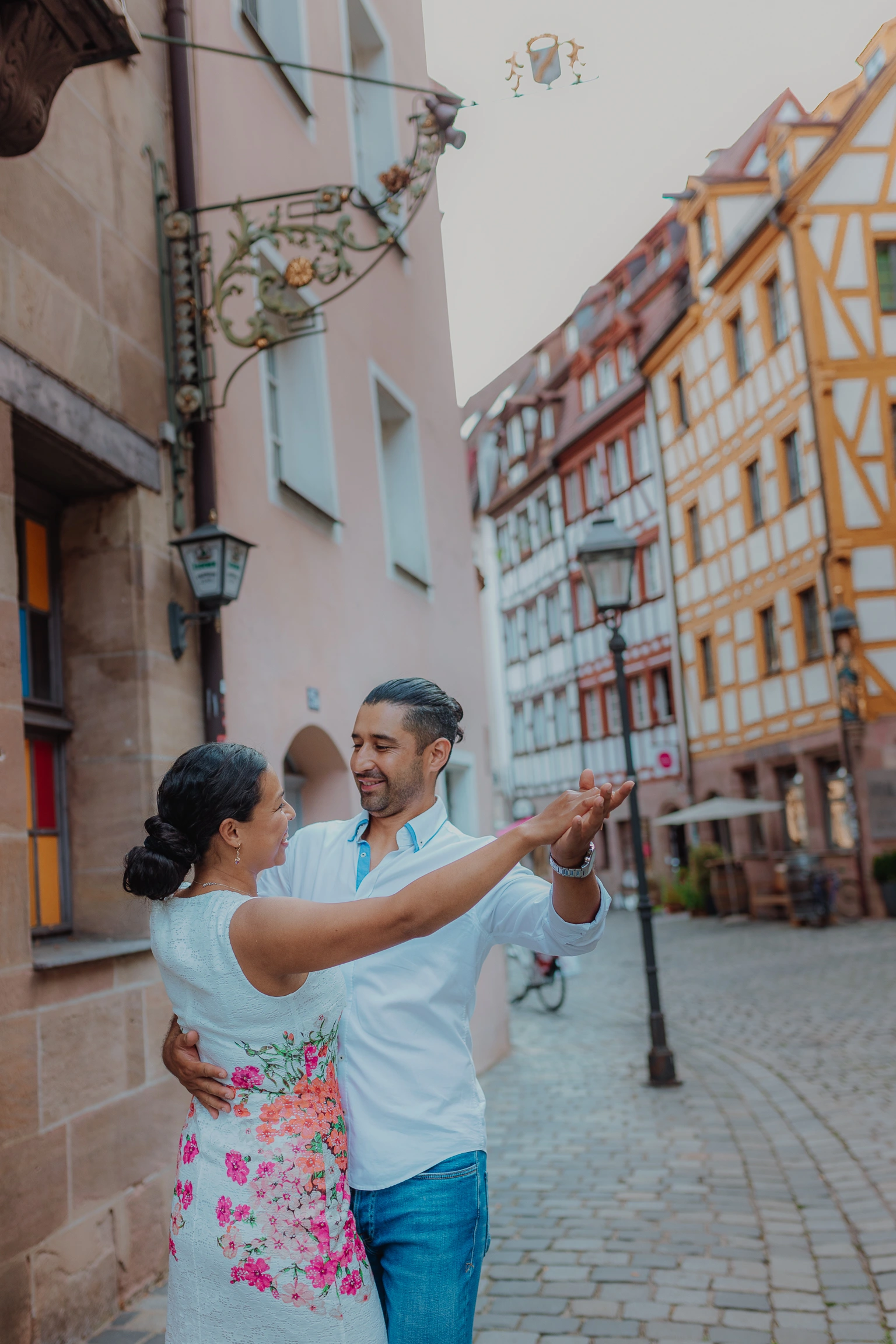 Woman pointing toward half timbered houses in a cobblestone lane