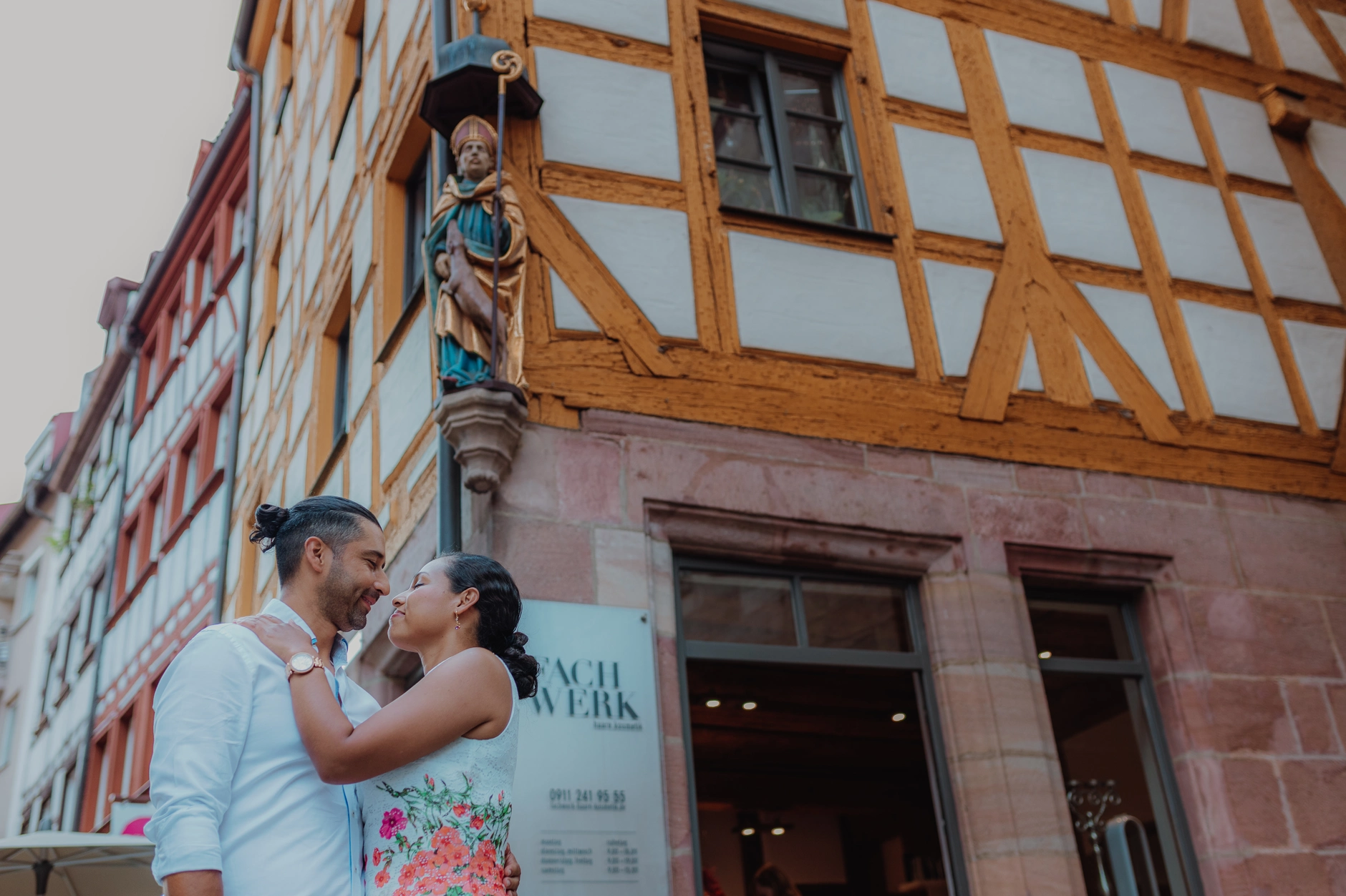 Couple seated on a vintage scooter in a half timbered street