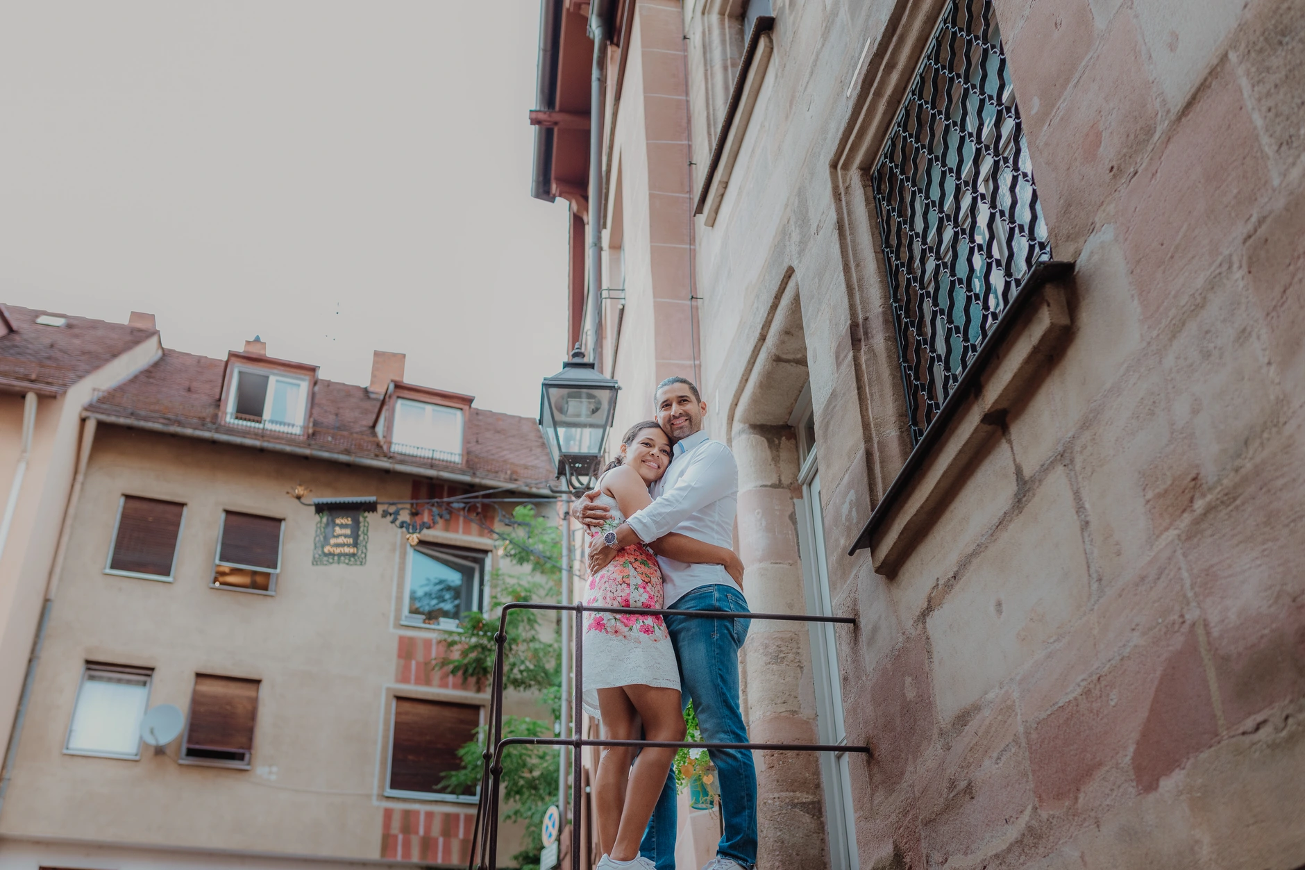 Couple laughing in front of half timbered houses and stone walls