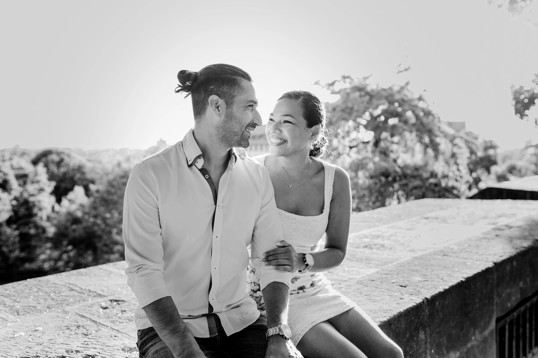 Black and white couple portrait by the wall with city view