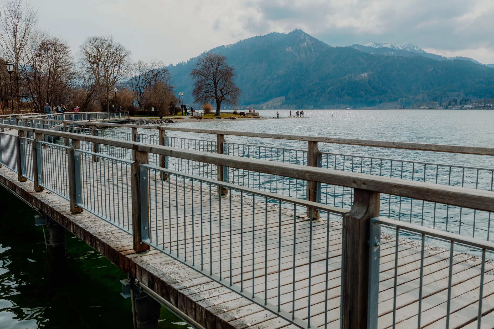 Wide boardwalk at Tegernsee with mountain backdrop
