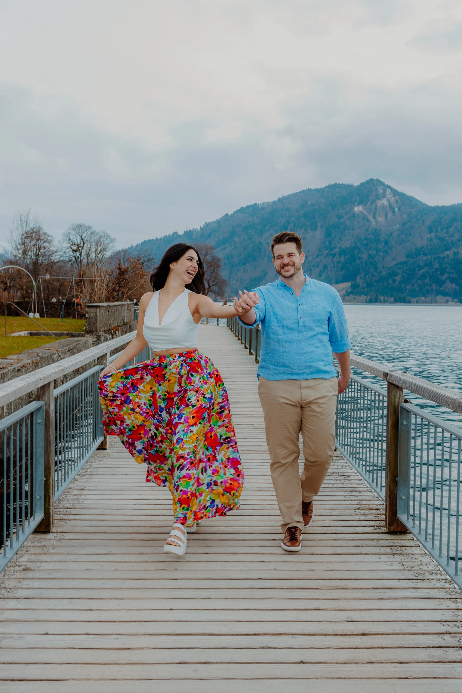 Couple walking hand in hand on the pier