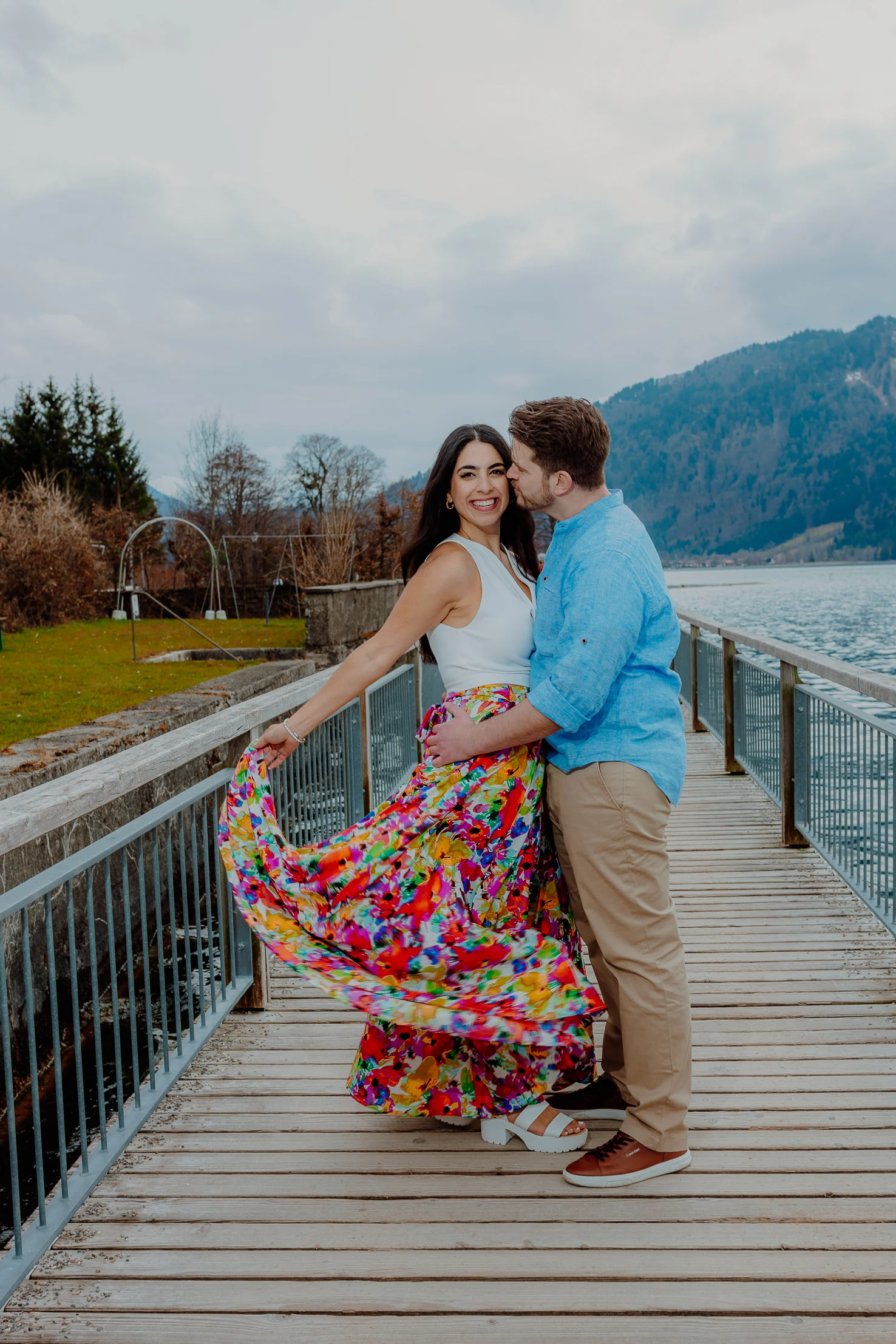 Couple seated on the railing with alpine scenery