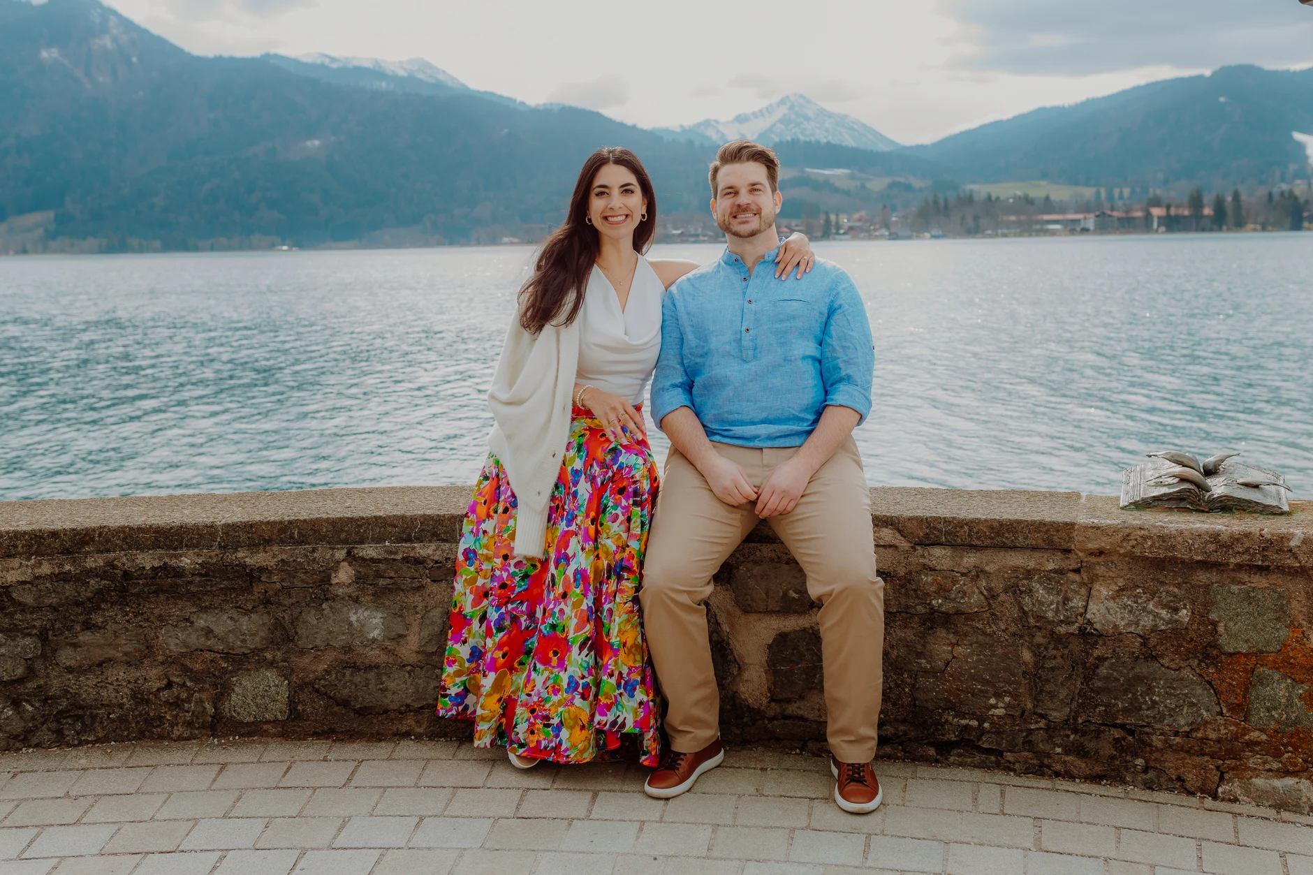 Couple sitting on a colorful blanket on the wooden pier