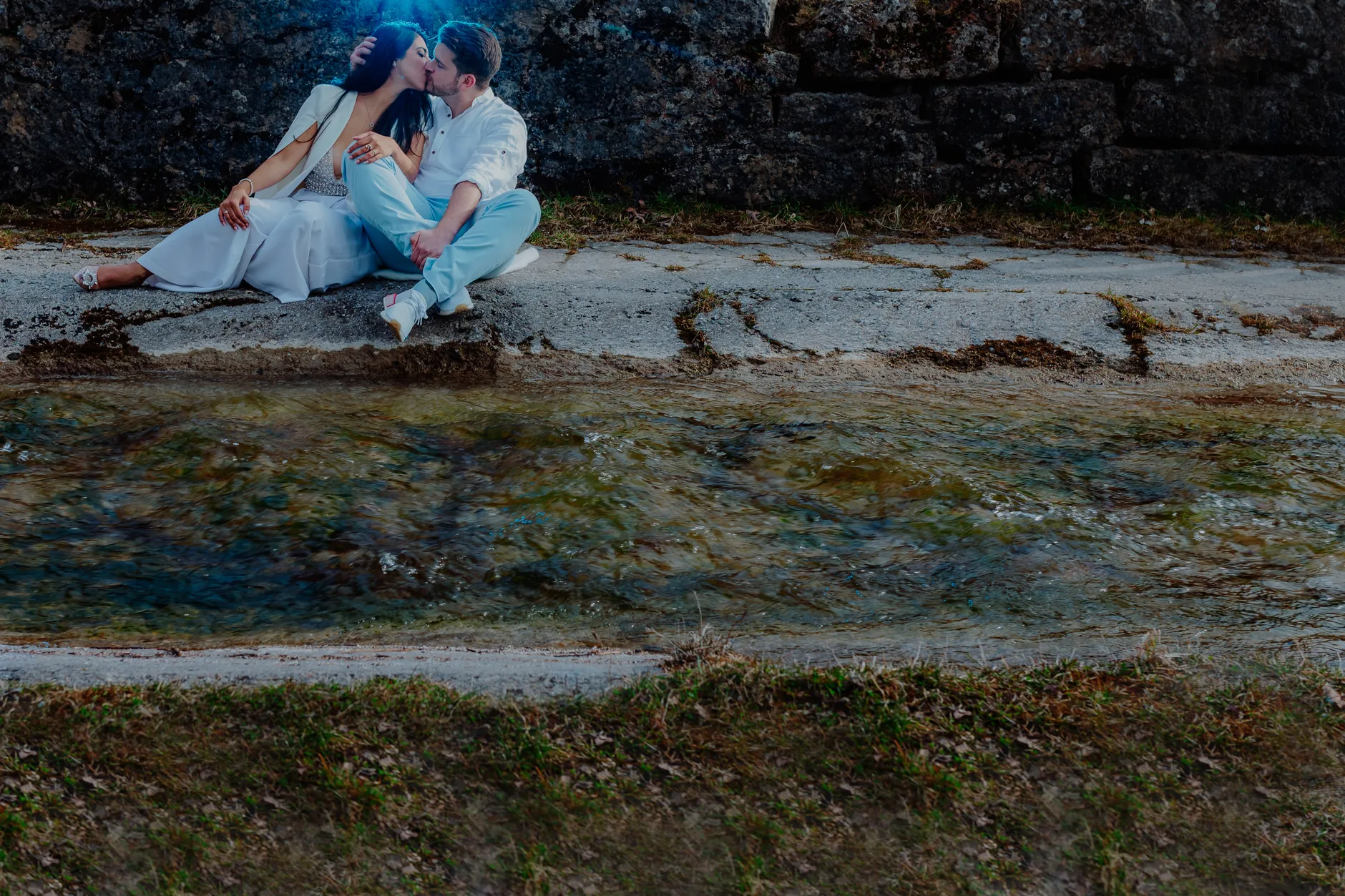Couple seated on stones by the lake