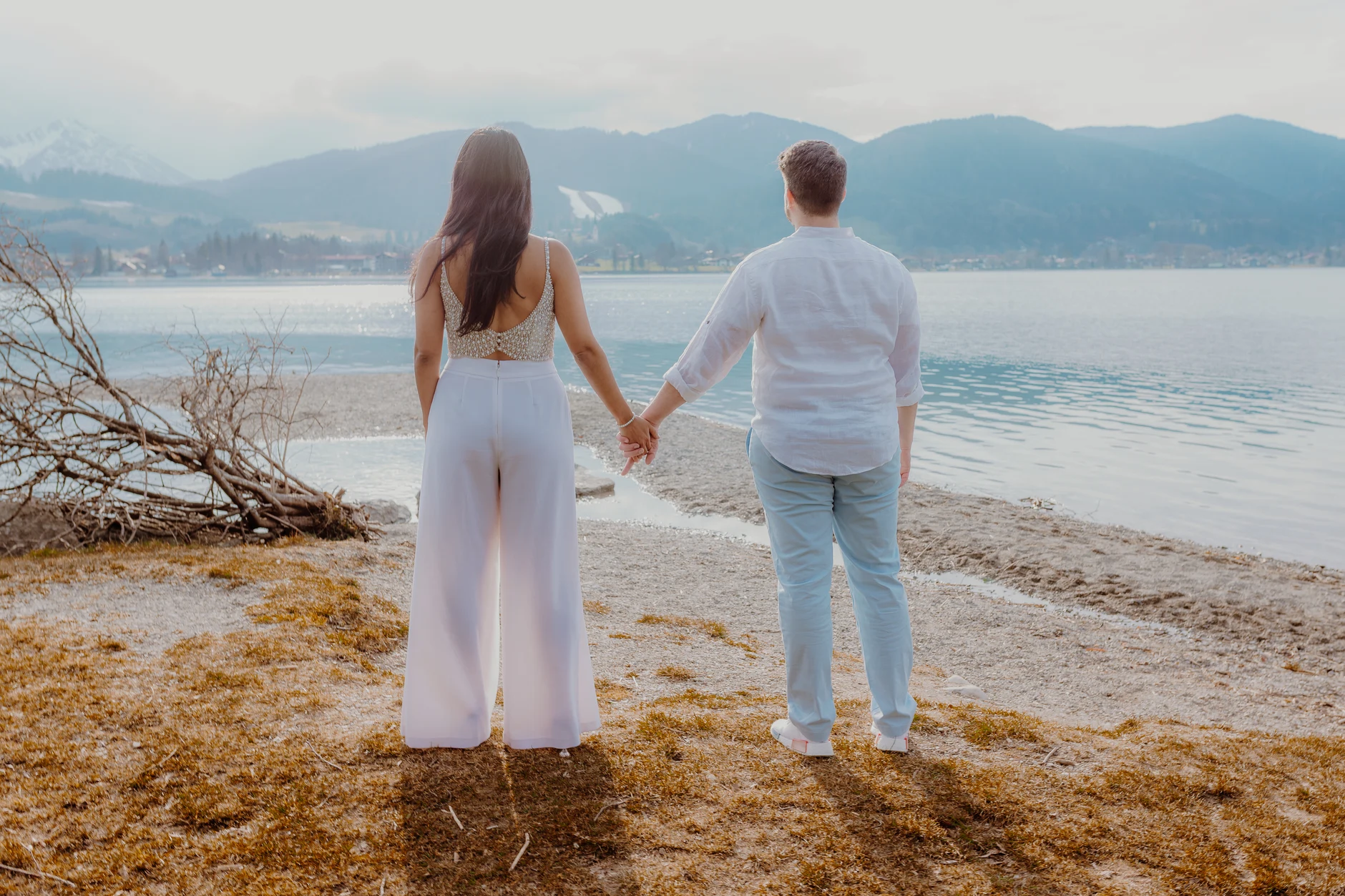 Couple walking along the beach in soft evening light