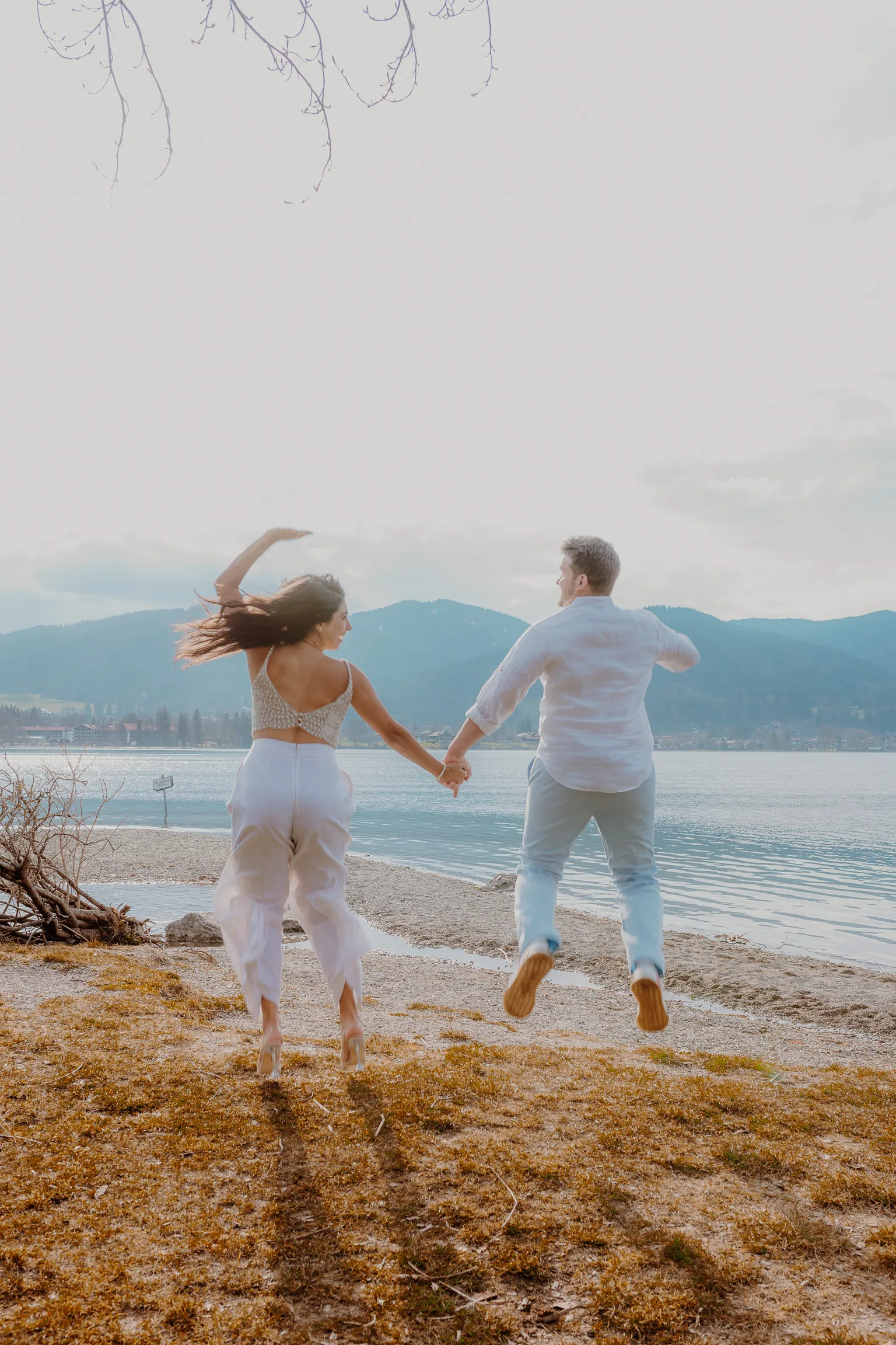 Playful walking shot of the couple by the shore