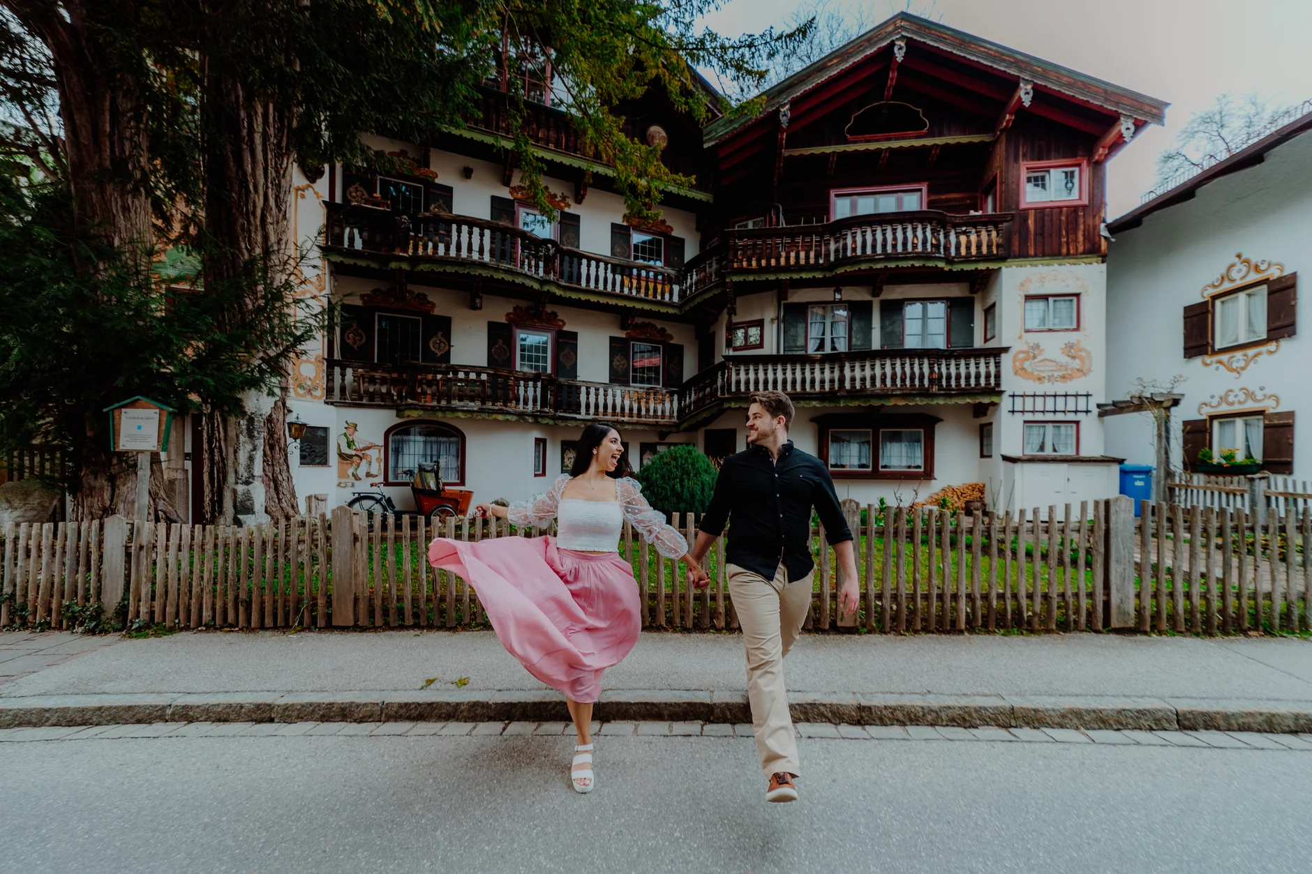 Wide final shot with flowing pink dress in front of alpine houses