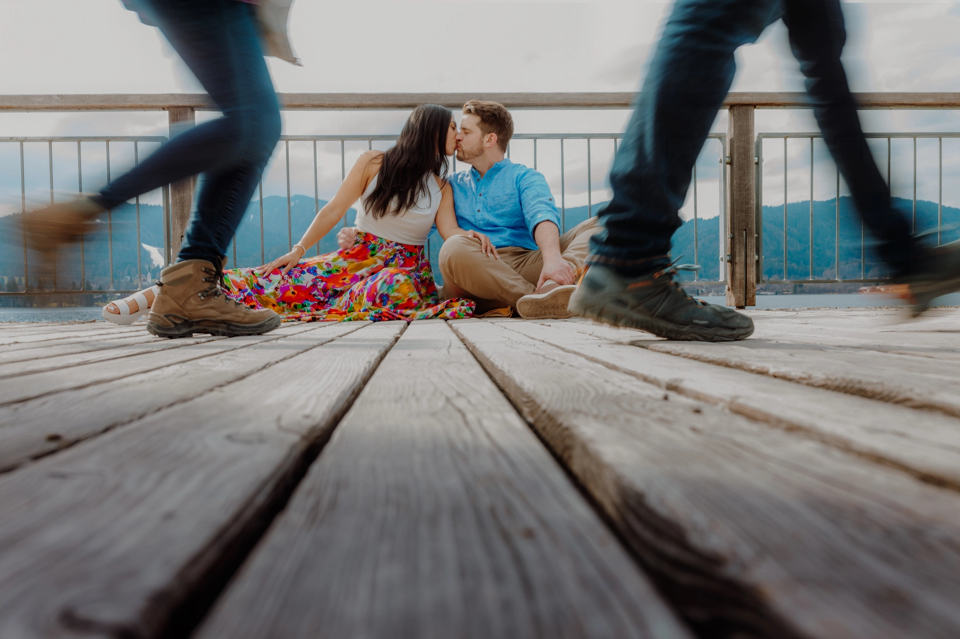 Couple sitting on a wooden dock at Tegernsee in the Bavarian Alps – couple photoshoot