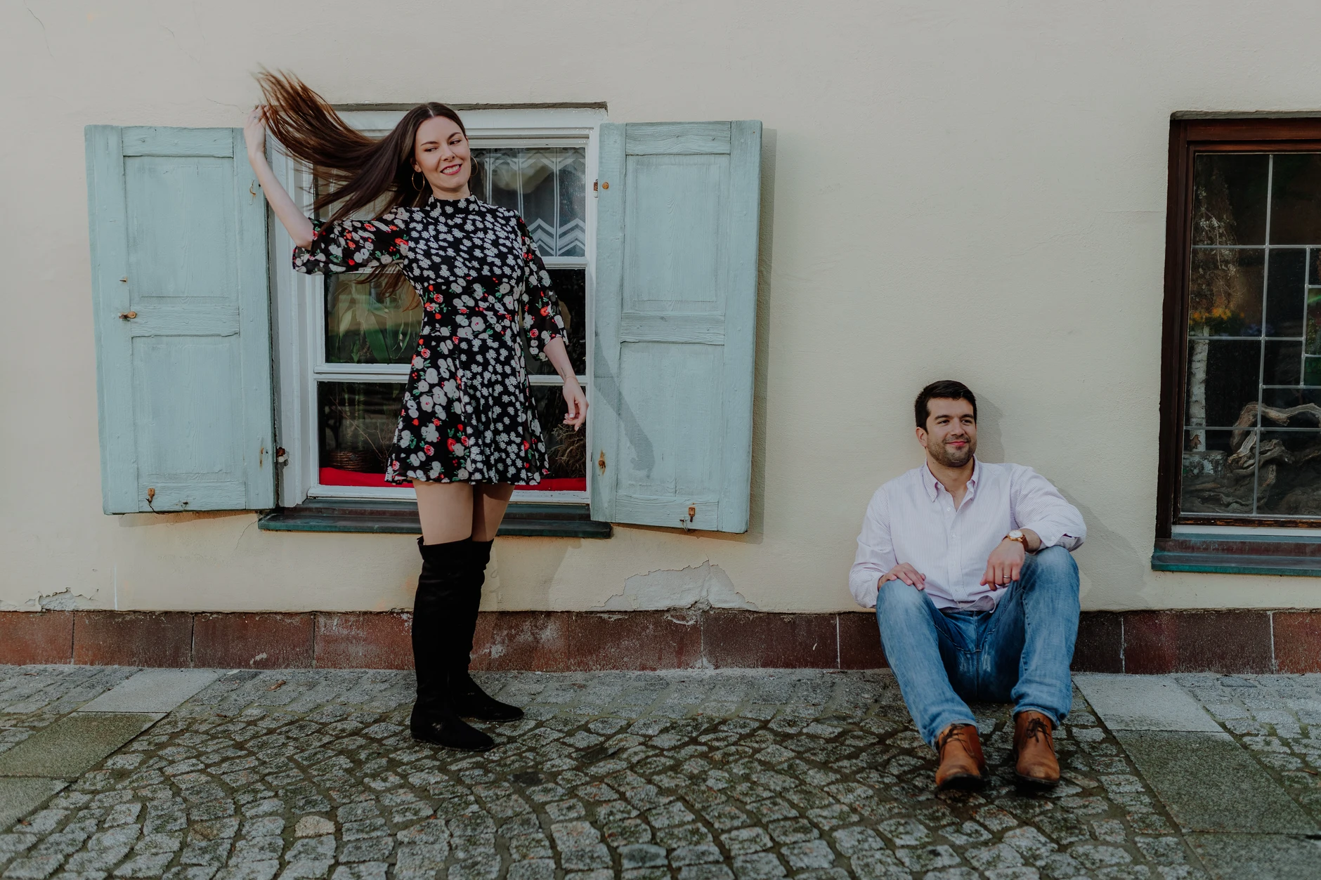 Woman in floral dress posing by the facade