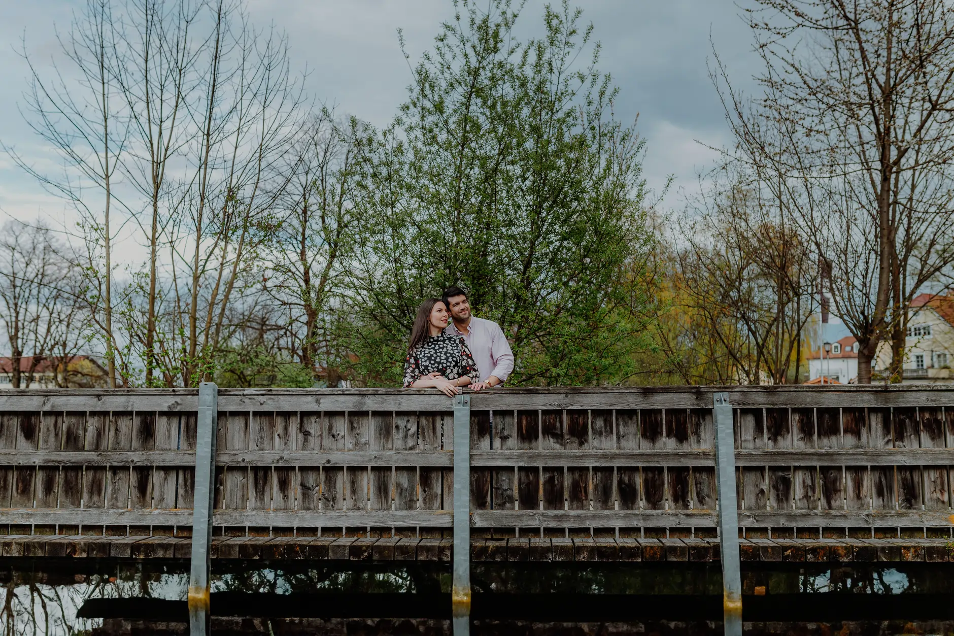 Couple sitting on the bridge railing above the river